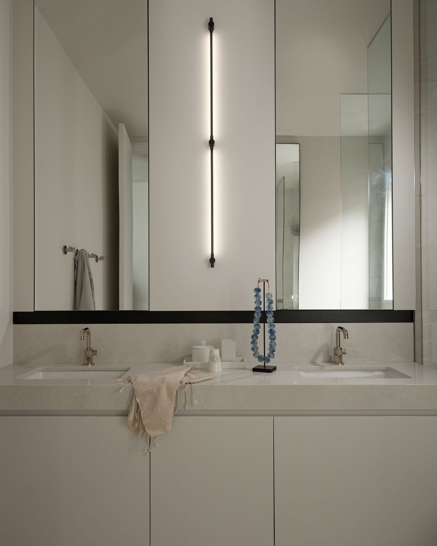 Repost @kimlambertdesign A minimalist ensuite for two.

Medicine cabinets sit behind tall metal framed mirrors providing ample storage, each accessed by a discrete tab pull. Designed prioritizing function and low maintenance and with teamwork, all as