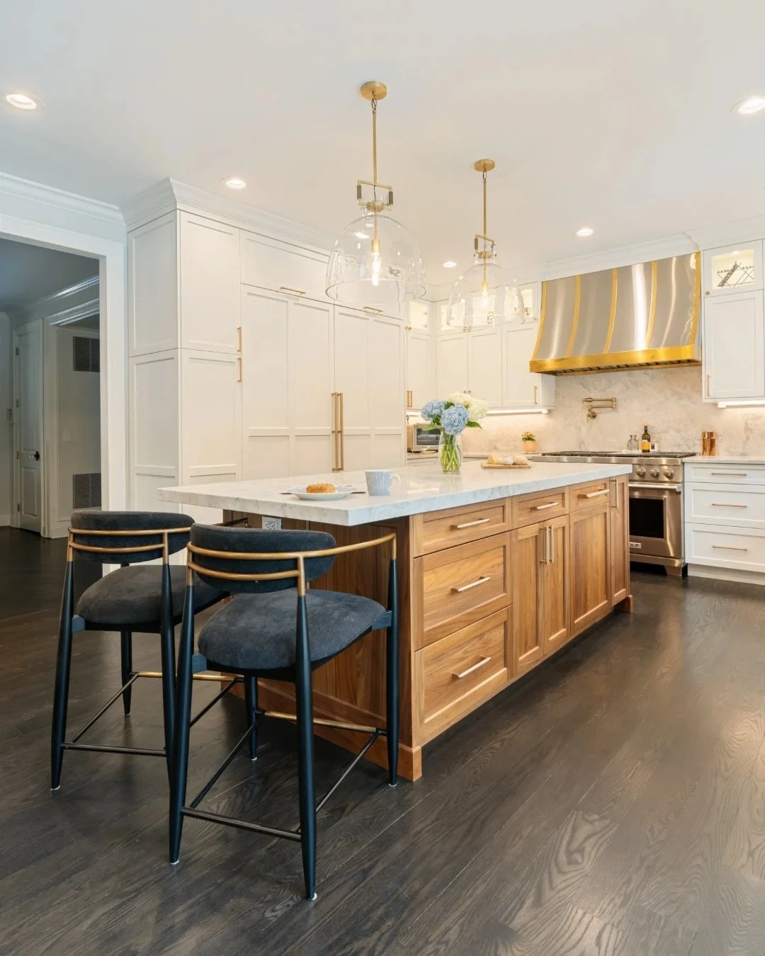 Two spaces, one cohesive design. From the kitchen to the dining area, every detail, the warm wood tones, brass accents, marble slab, and custom cabinetry, was chosen to work together seamlessly. This is what it looks like when a home is designed as a