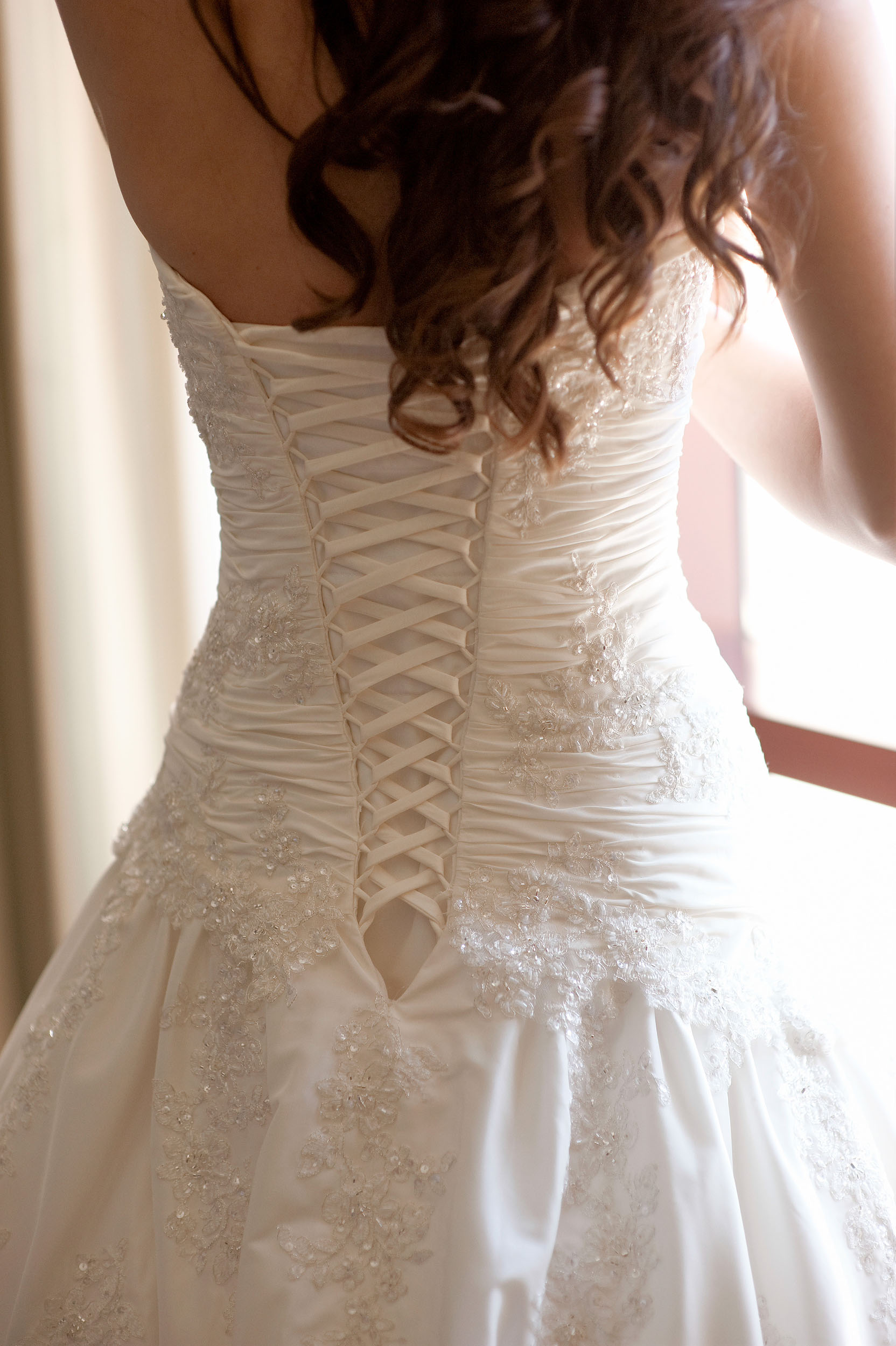 Lacing on back of bride's wedding dress at Pechanga Resort & Casino in Temecula.