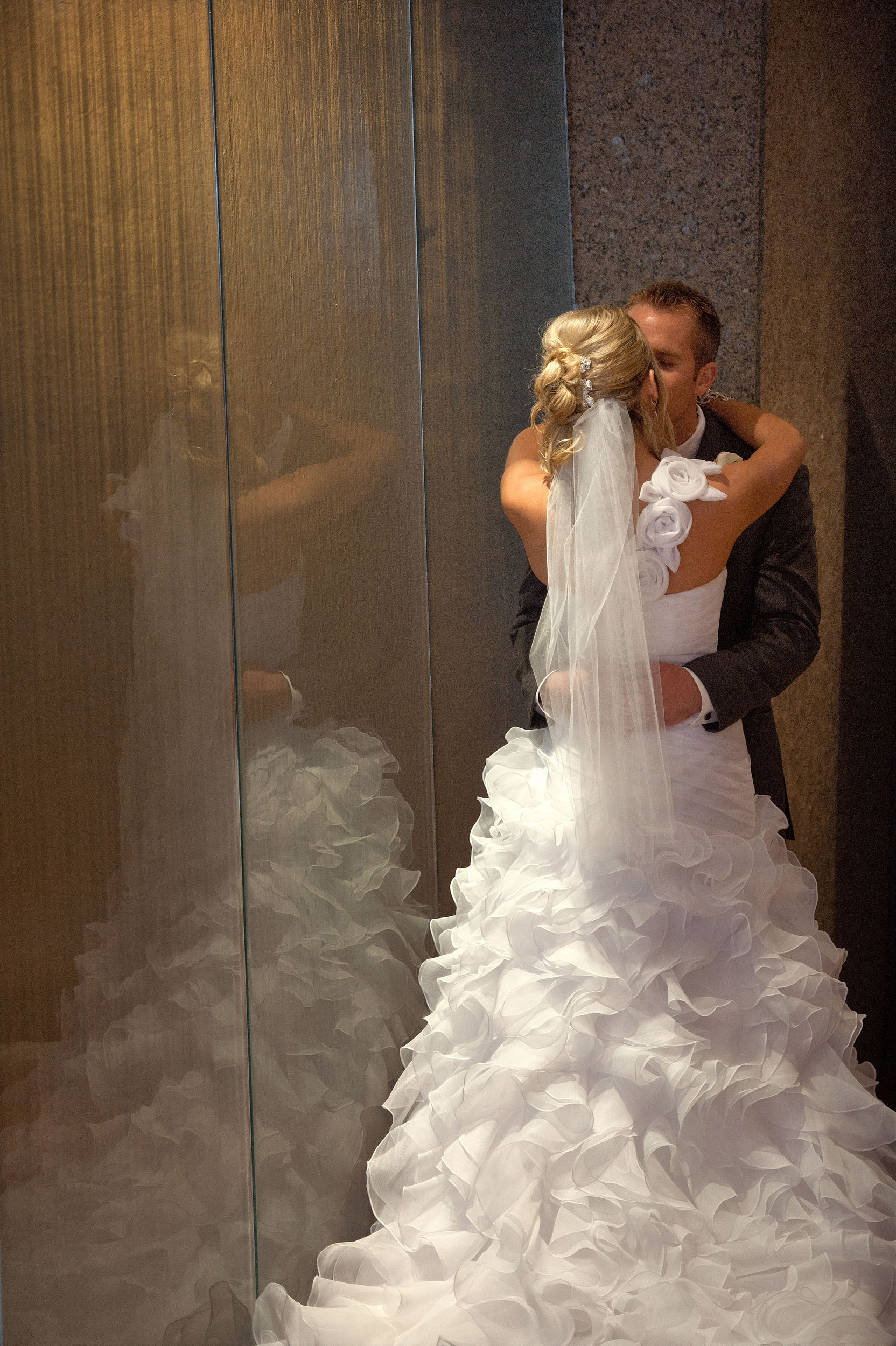Bride and groom by glass wall at Seven-Degrees in Laguna Beach.
