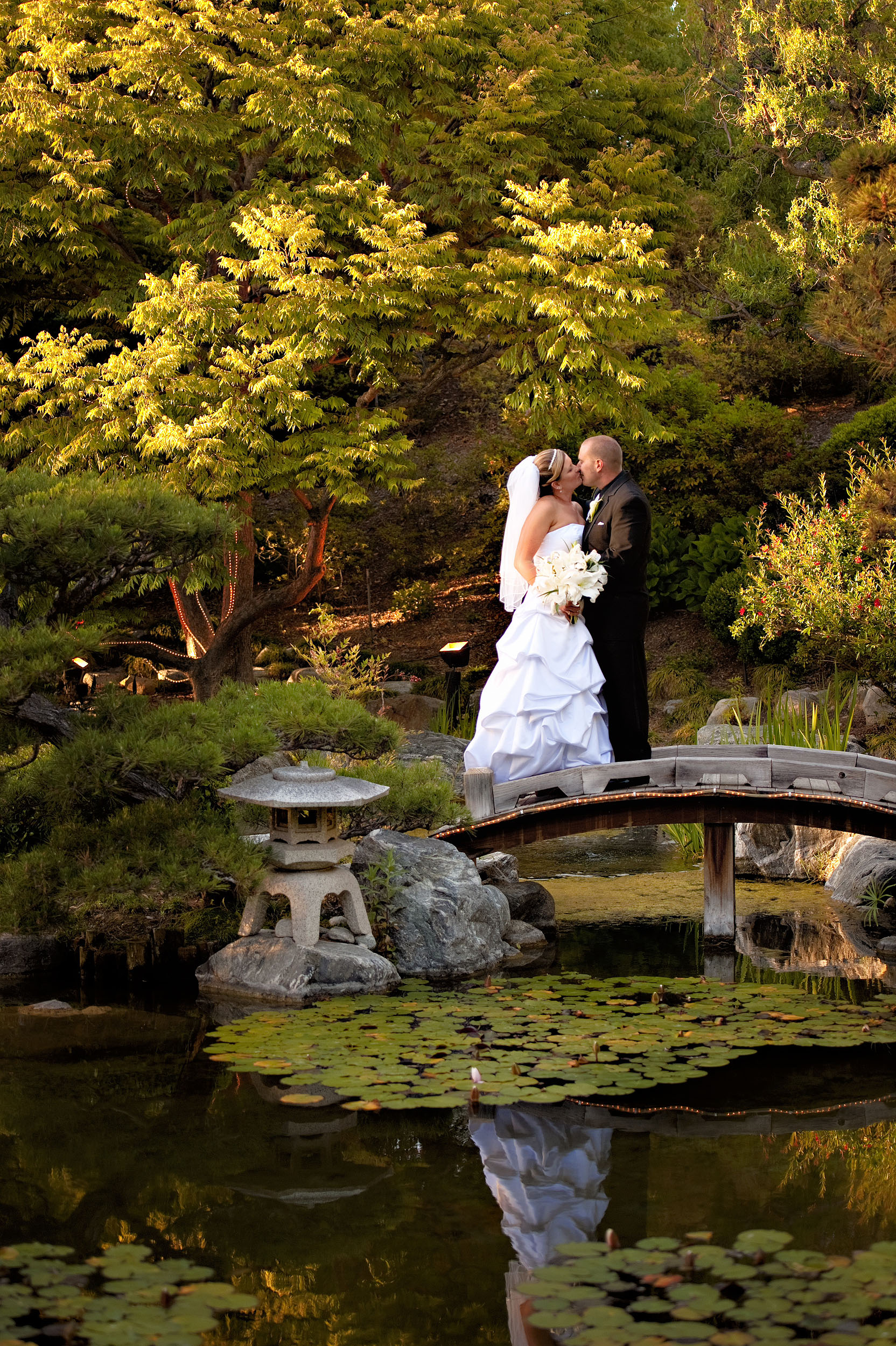 Bride and groom kissing on bridge in Japanese Garden at the Sorrento Mesa Karl Strauss Brewing Company in San Diego.