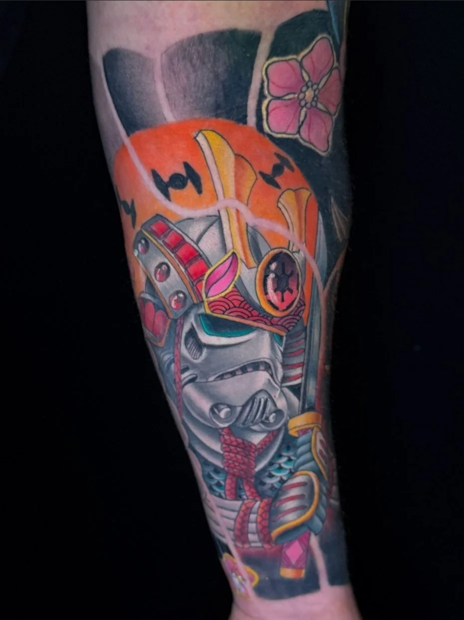 Colorful tattoo depicting a stormtrooper from Star Wars wearing a Samurai helmet and armor, holding a sword with a floral and abstract background.
