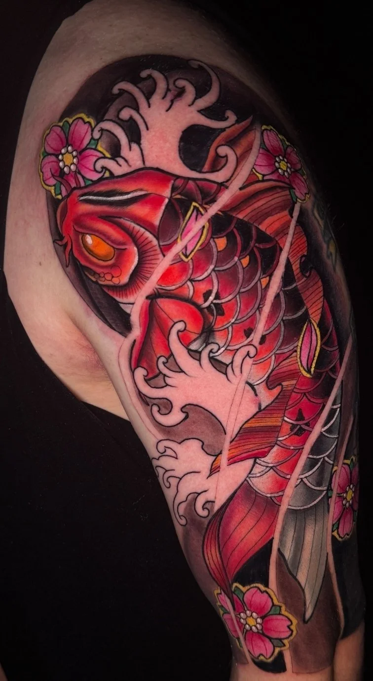 A colorful tattoo of a koi fish with orange, red, and black scales surrounded by pink cherry blossoms and stylized water waves.