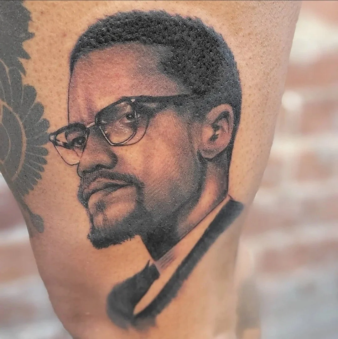 Black and grey tattoo portrait of Malcom X