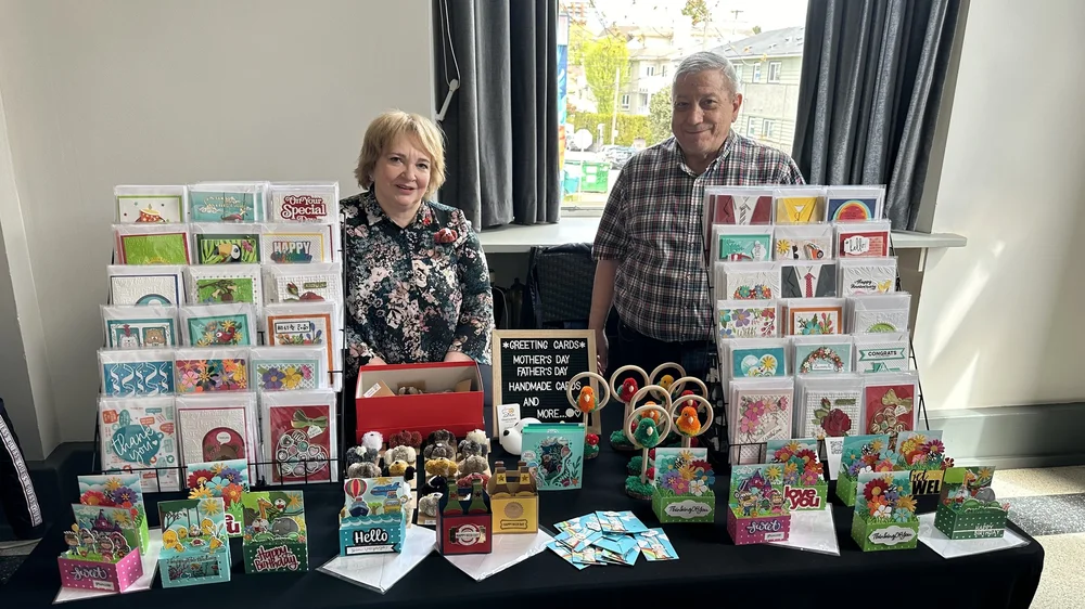 Local makers sharing greeting cards and handmade creations at their booth
