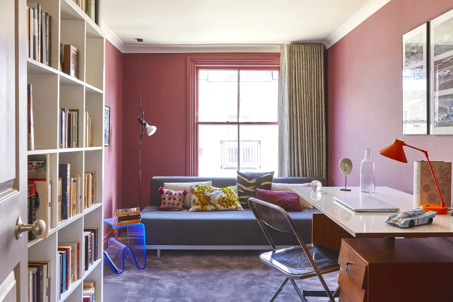 image of period home with pink walls and colourful lamp and cushions inside a study