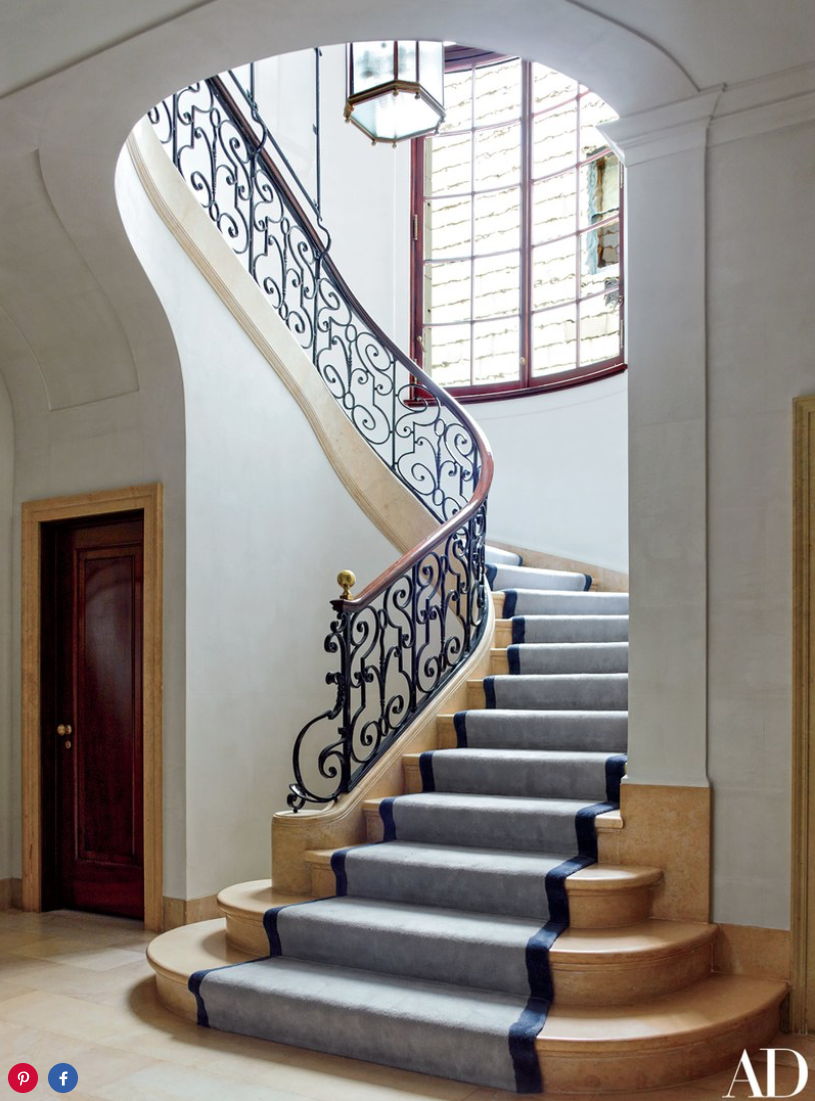 The staircase, showcasing its original 1912 balustrade, is softened by a Beauvais runner. 
