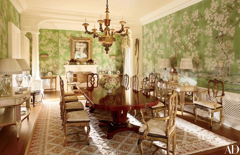 A Gracie chinoiserie paper lines the dining room, which is outfitted with Italian Rococo chairs and custom-made copies; Frederick P. Victoria & Son created the cream-painted consoles, and the carpet is a bespoke Axminster.