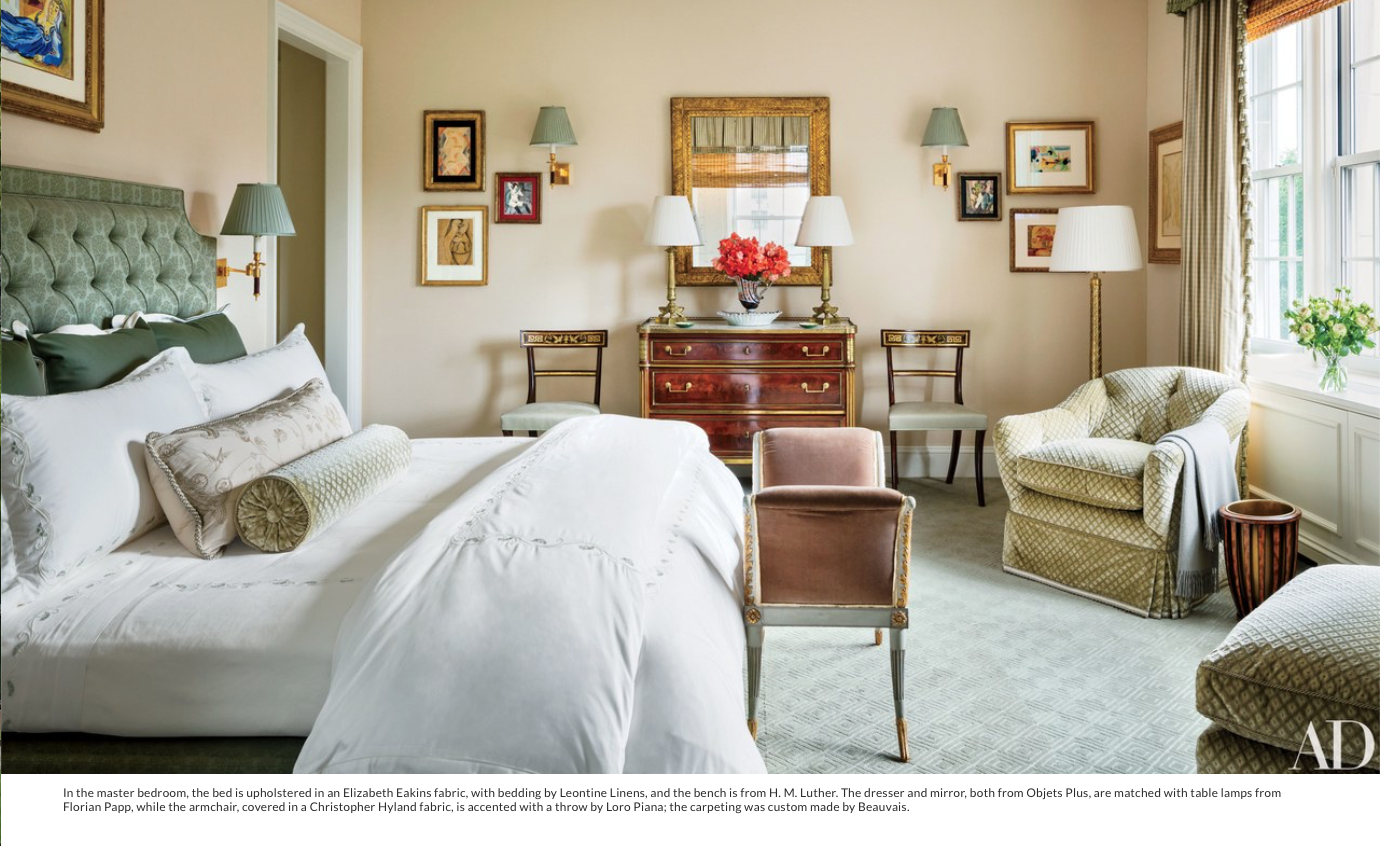 In the master bedroom, the bed is upholstered in an Elizabeth Eakins fabric, with bedding by Leontine Linens, and the bench is from H. M. Luther. The dresser and mirror, both from Objets Plus, are matched with table lamps from Florian Papp, while the armchair, covered in a Christopher Hyland fabric, is accented with a throw by Loro Piana; the carpeting was custom made by Beauvais.