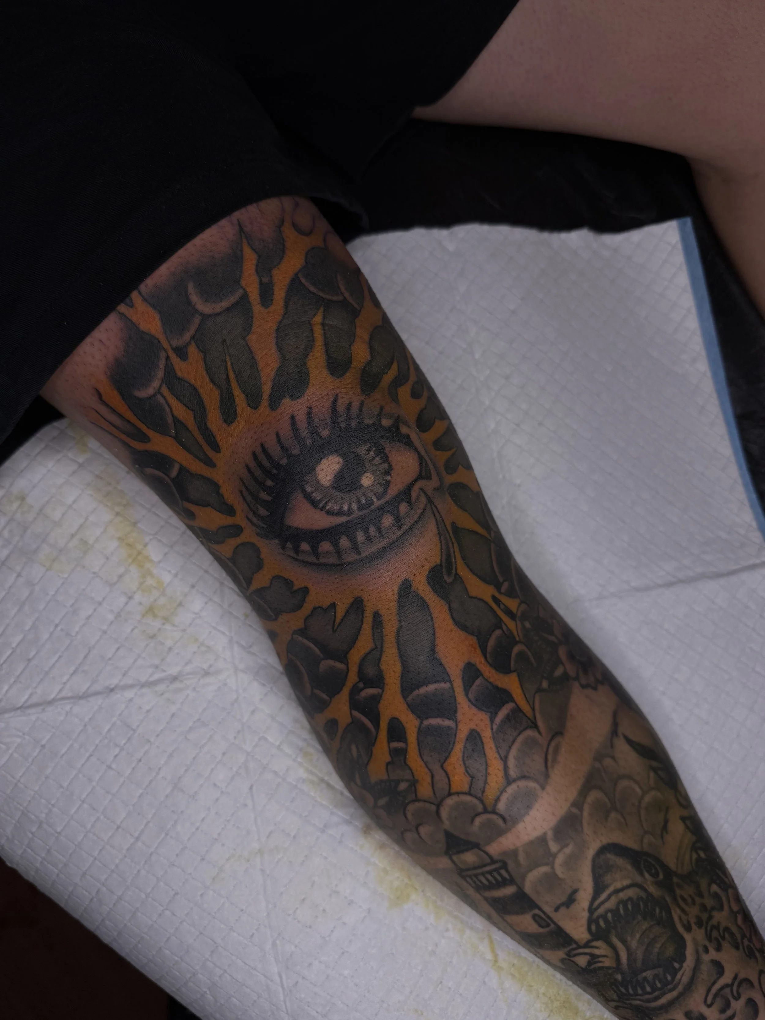 colour traditional bold knee tattoo eye lightning and clouds central coast tattoo studio australia