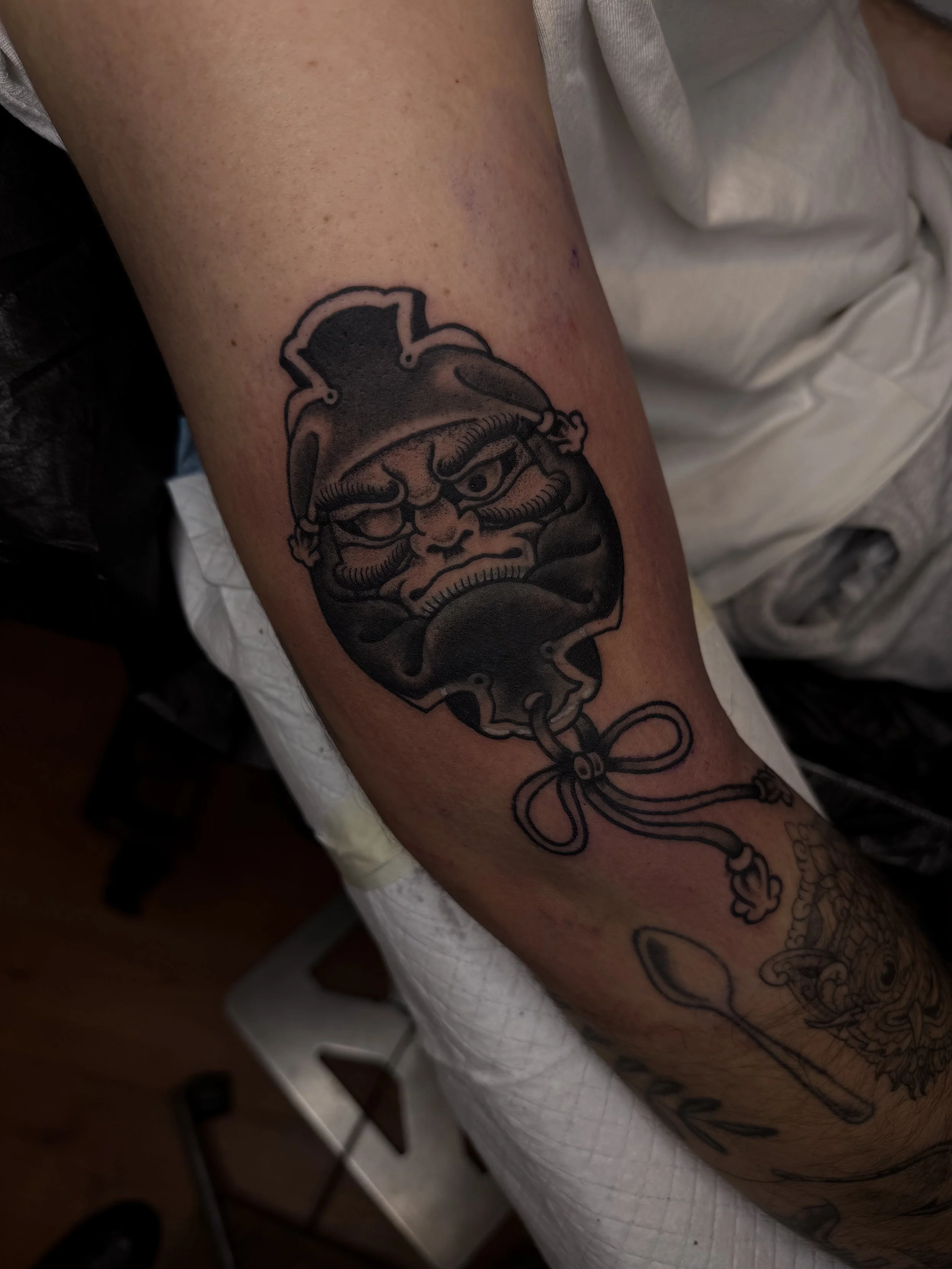 daruma doll bold traditional tattoo upper arm