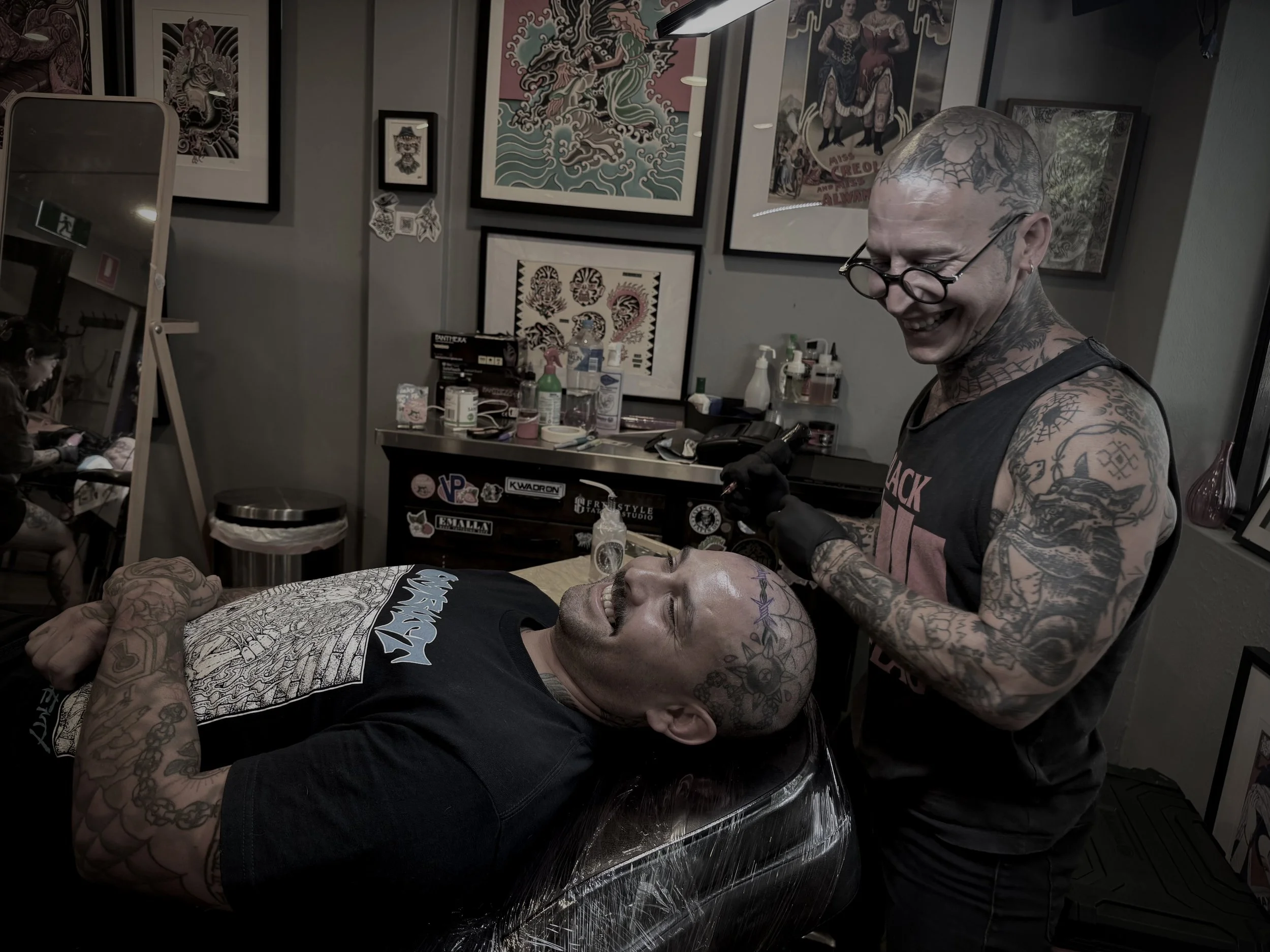 traditional tattoo artist portrait tattooing client's head tattoo 