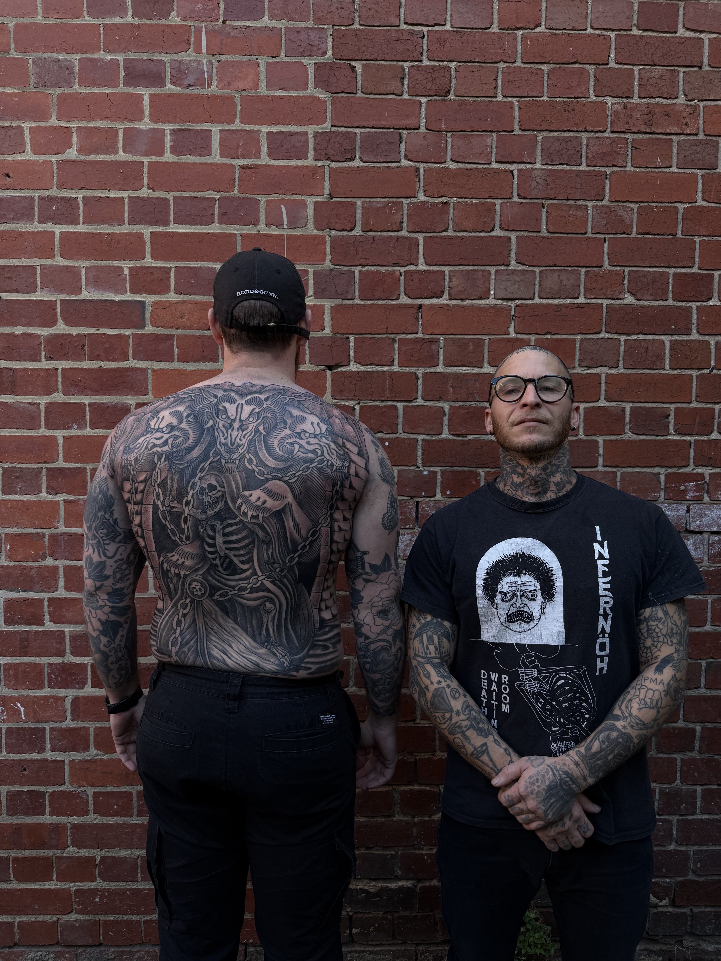 tattoo artist with client back tattoo bold traditional 