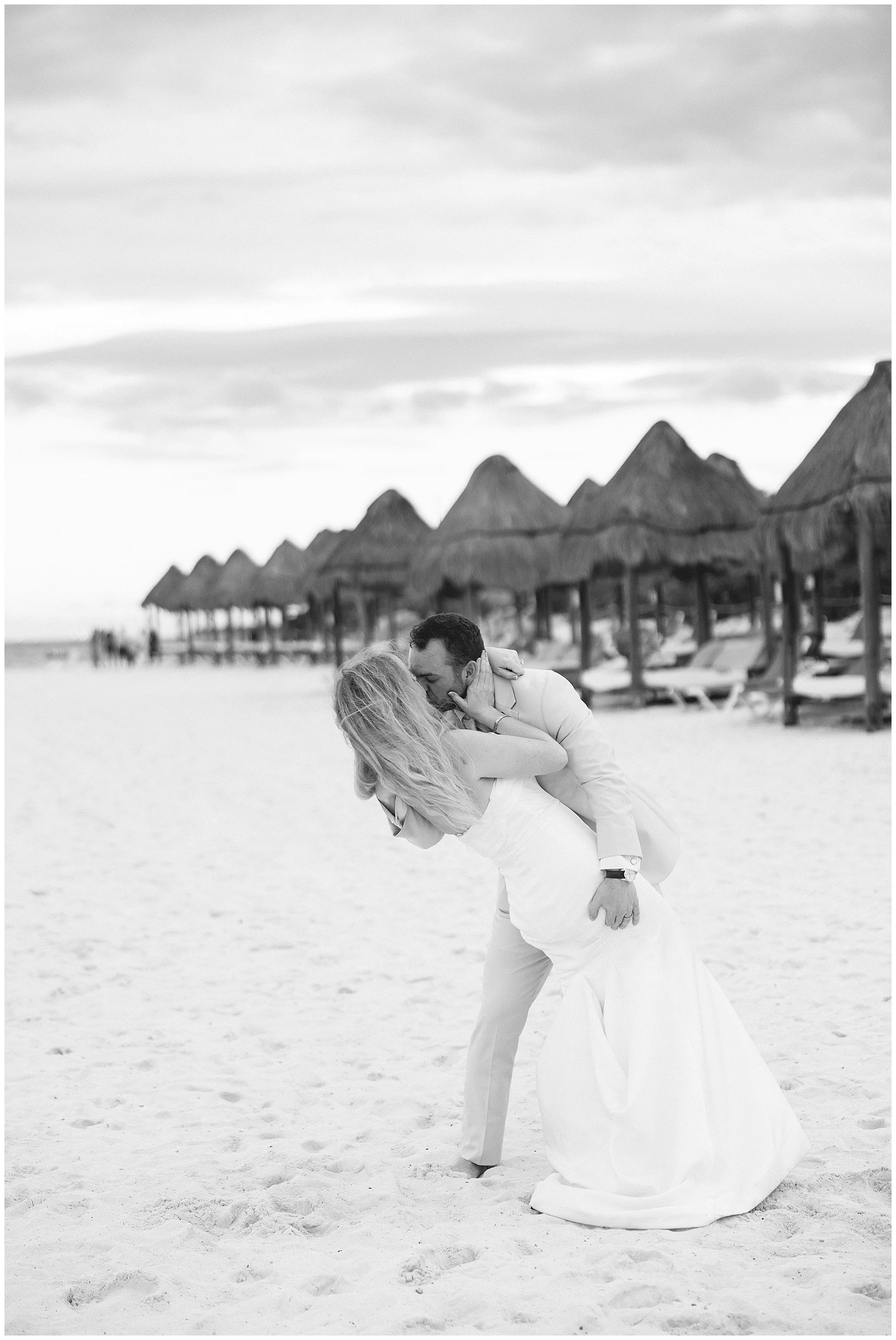 bride and groom kissing on beach at valentin imperial resort riviera maya