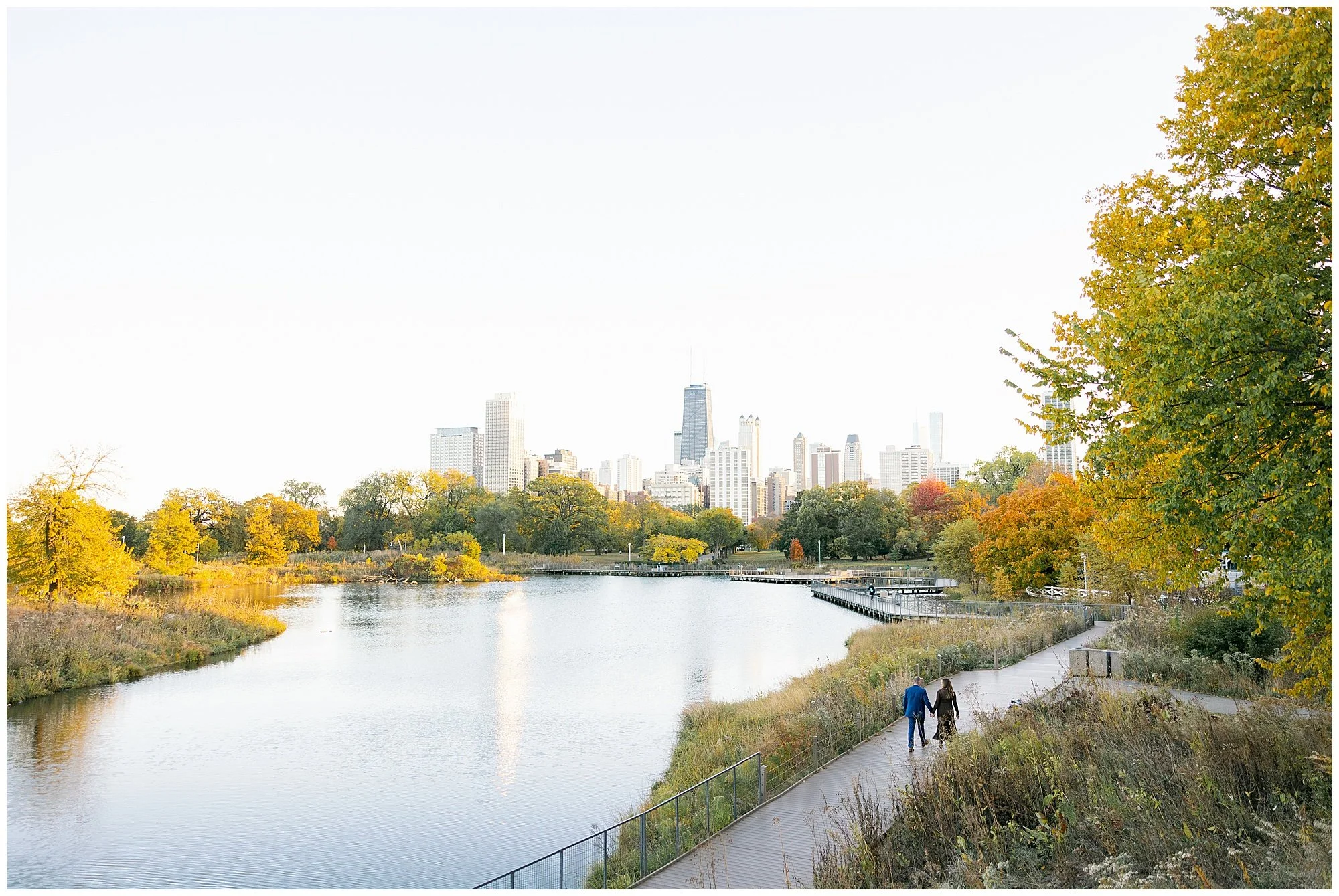  wide shot of couple walking by pond at nature boardwalk in lincoln park zoo 