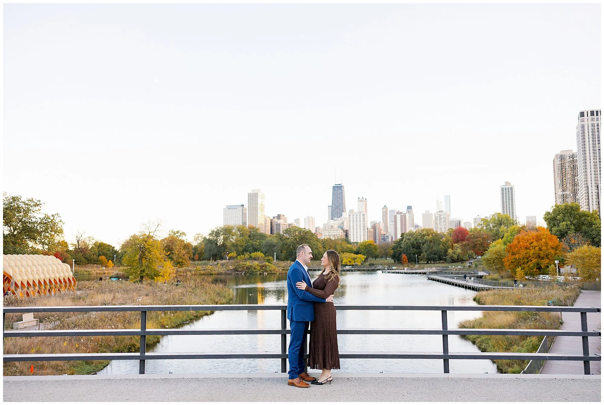  wide shot of couple in front of chicago skyline at nature boardwalk in lincoln park zoo 