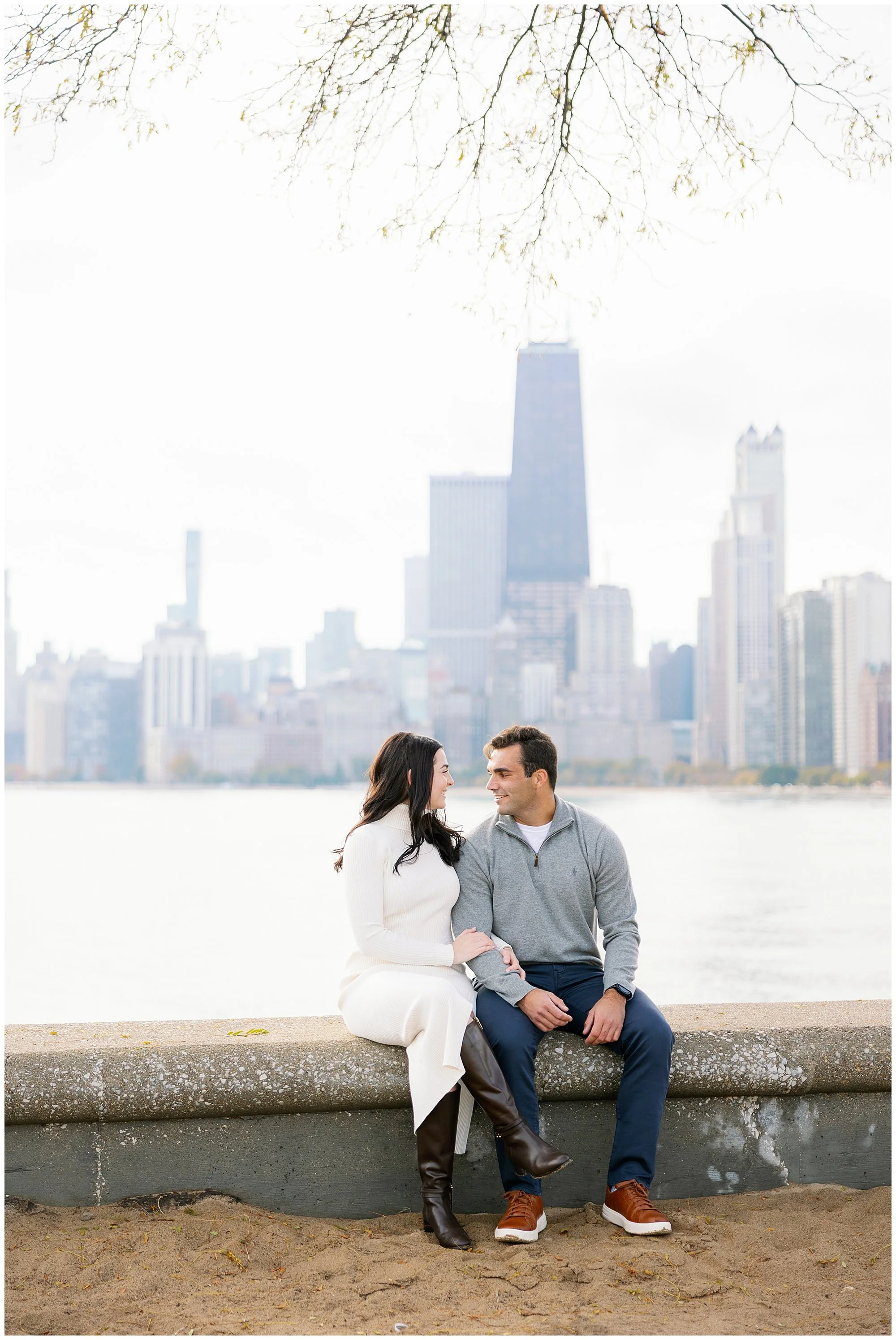  couple sitting in front of skyline at north avenue beach 