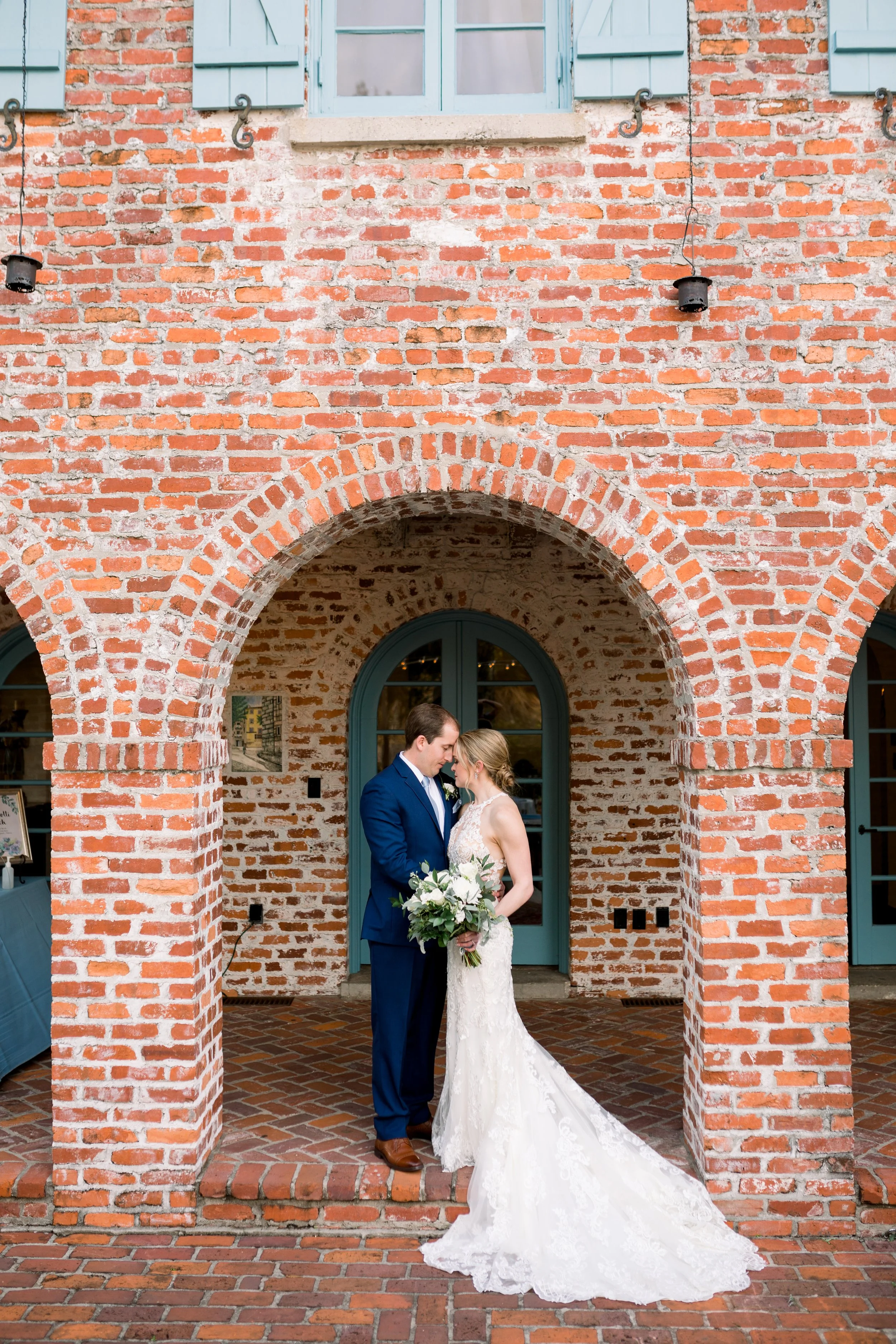 A bride and groom standing closely together under a brick archway at Casa Feliz Historic Home in Winter Park Florida