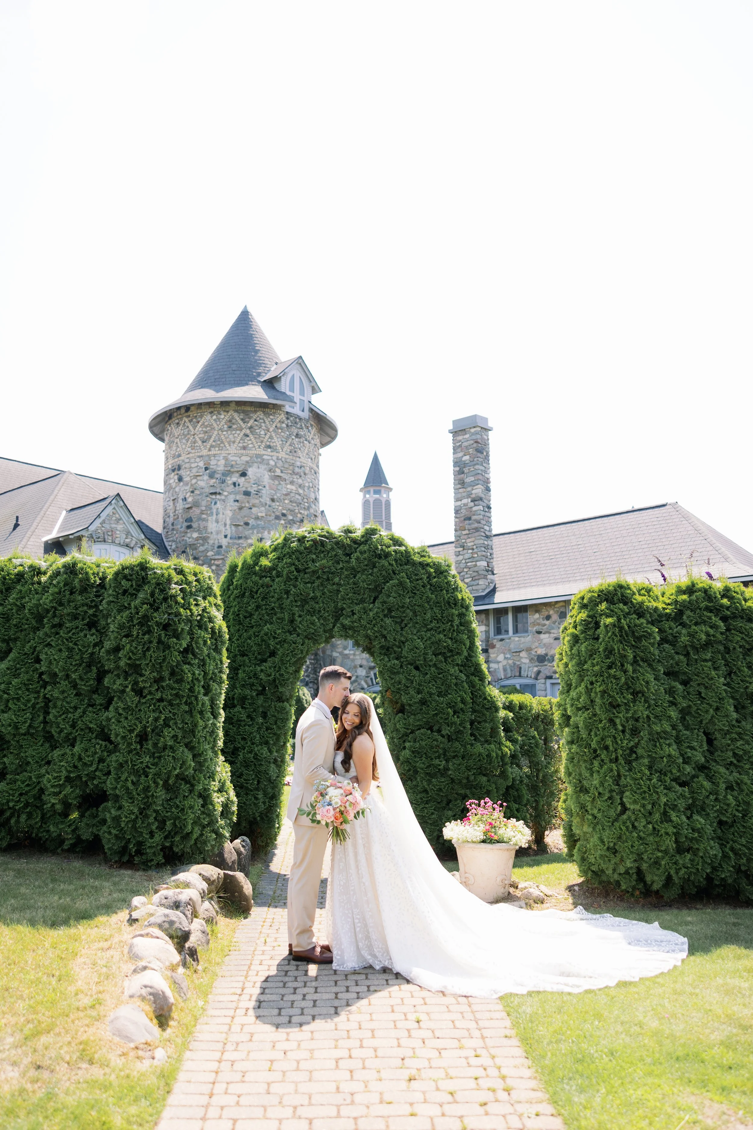 bride and groom kissing and cuddling in front of castle farms northern michigan