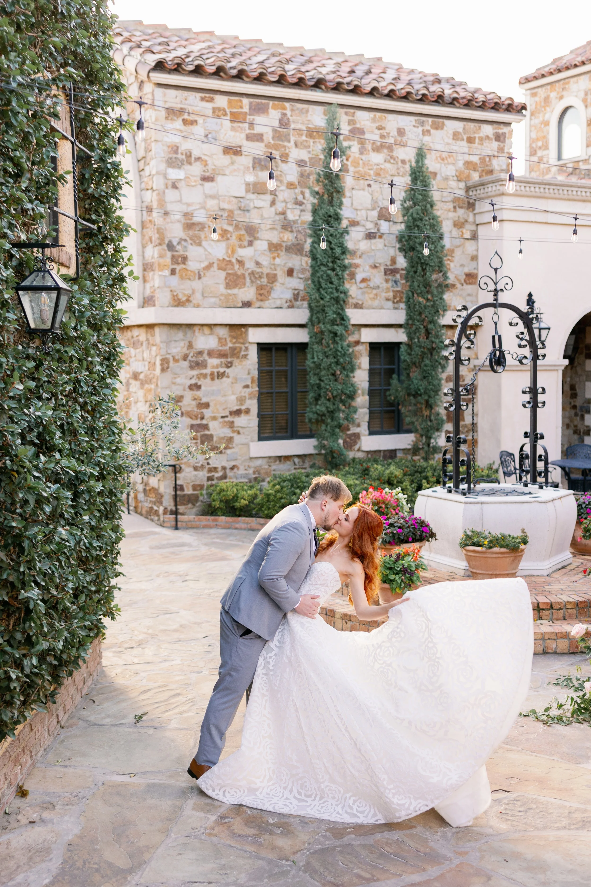 bride and groom kissing in courtyard at bella collina