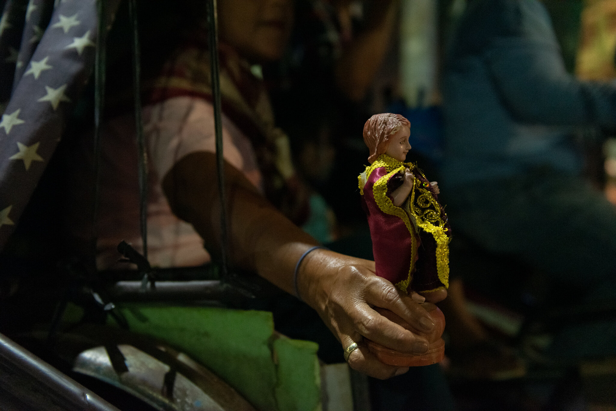  A woman holds a small image of the child Jesus as they wait for the command of the polics to join the  procession. 