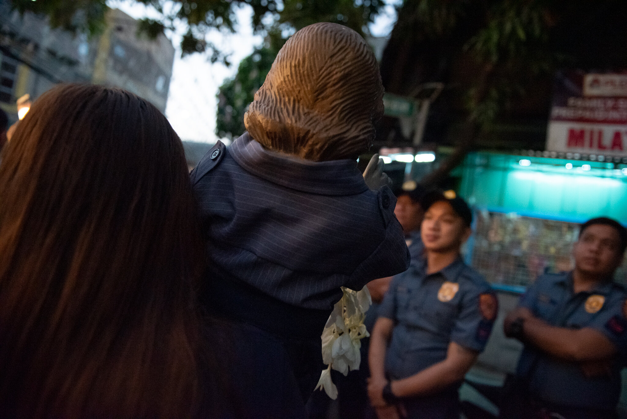  An image of the child Jesus wearing a cop costume parades in front of Filipino policemen. 
