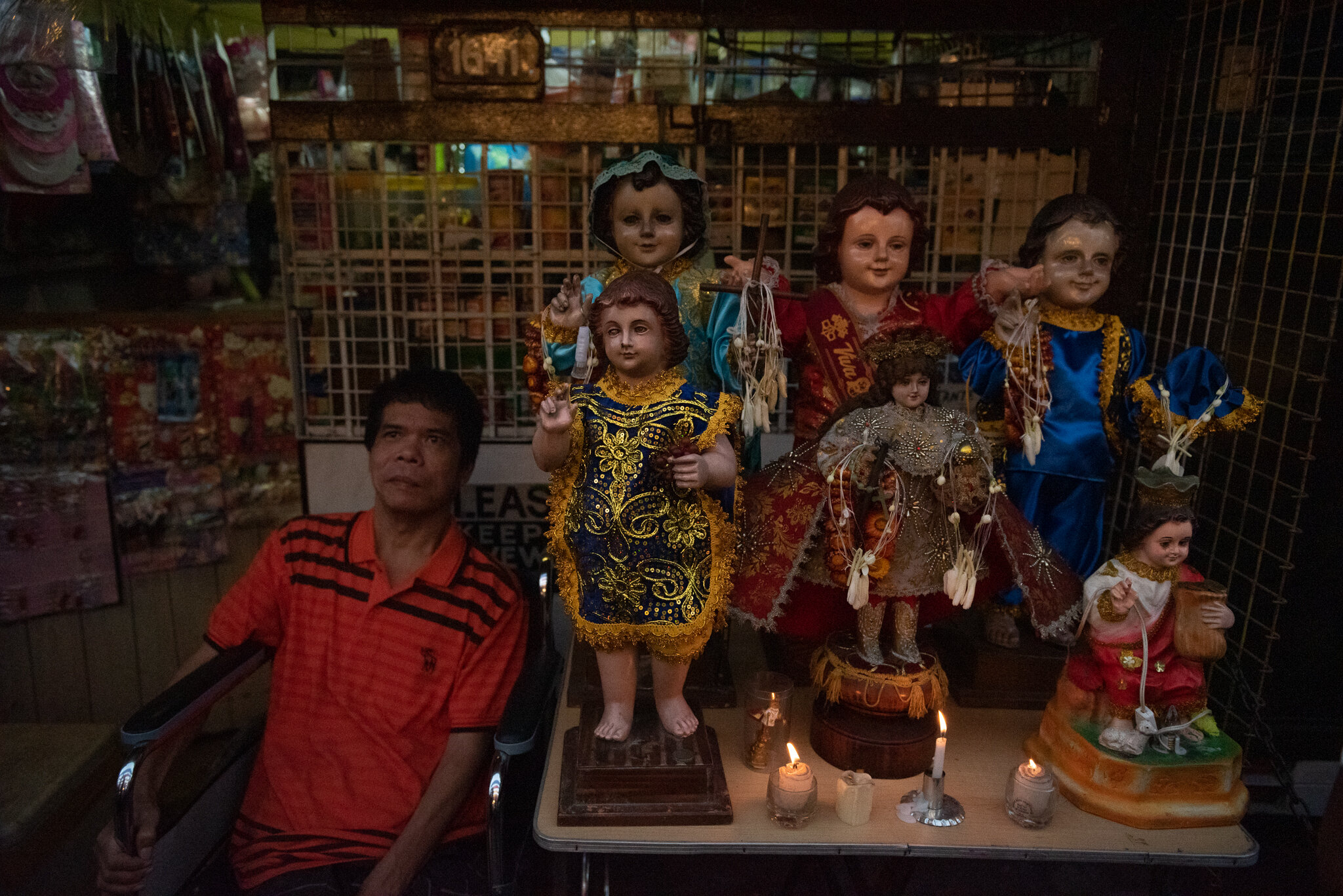  A handicapped man watches the procession from outside his store. 