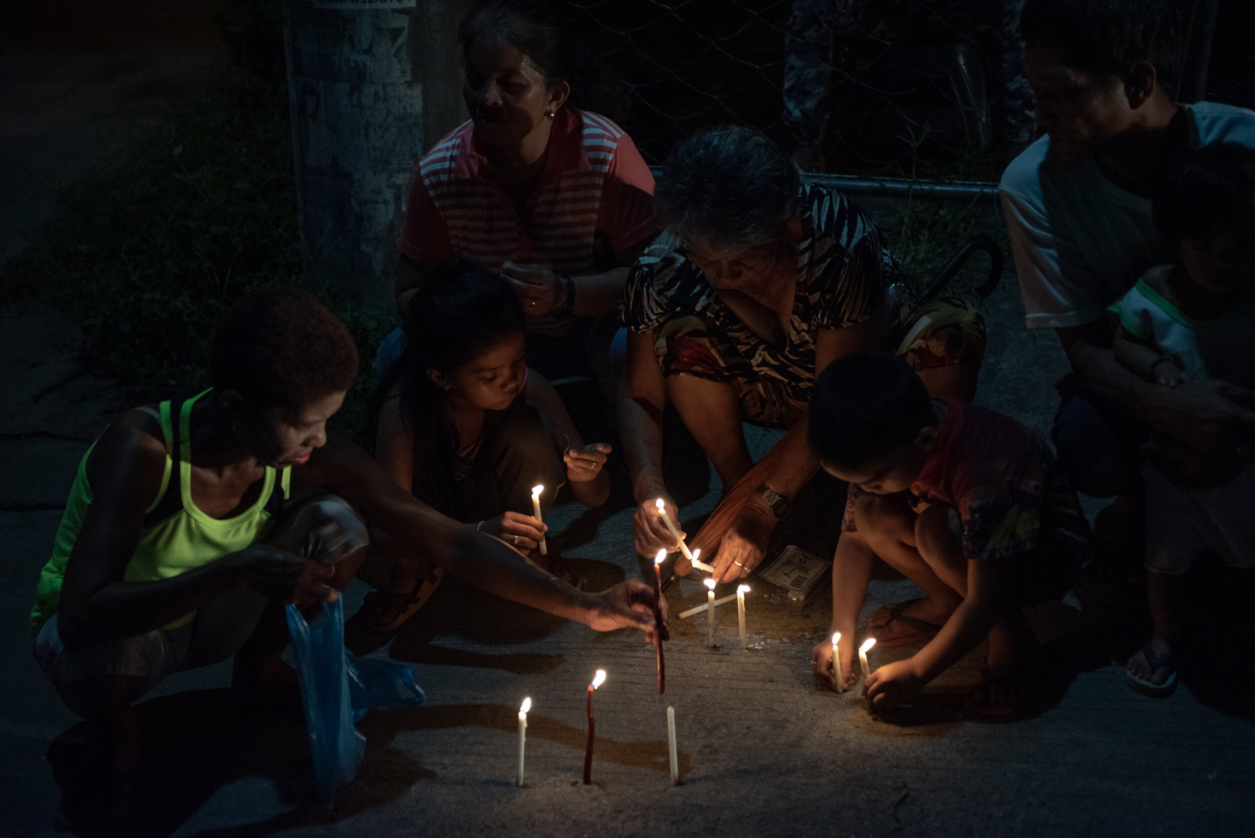  A family light up candles along the streets of Tacloban City to commemorate the 6th Yolanda Anniversary. 