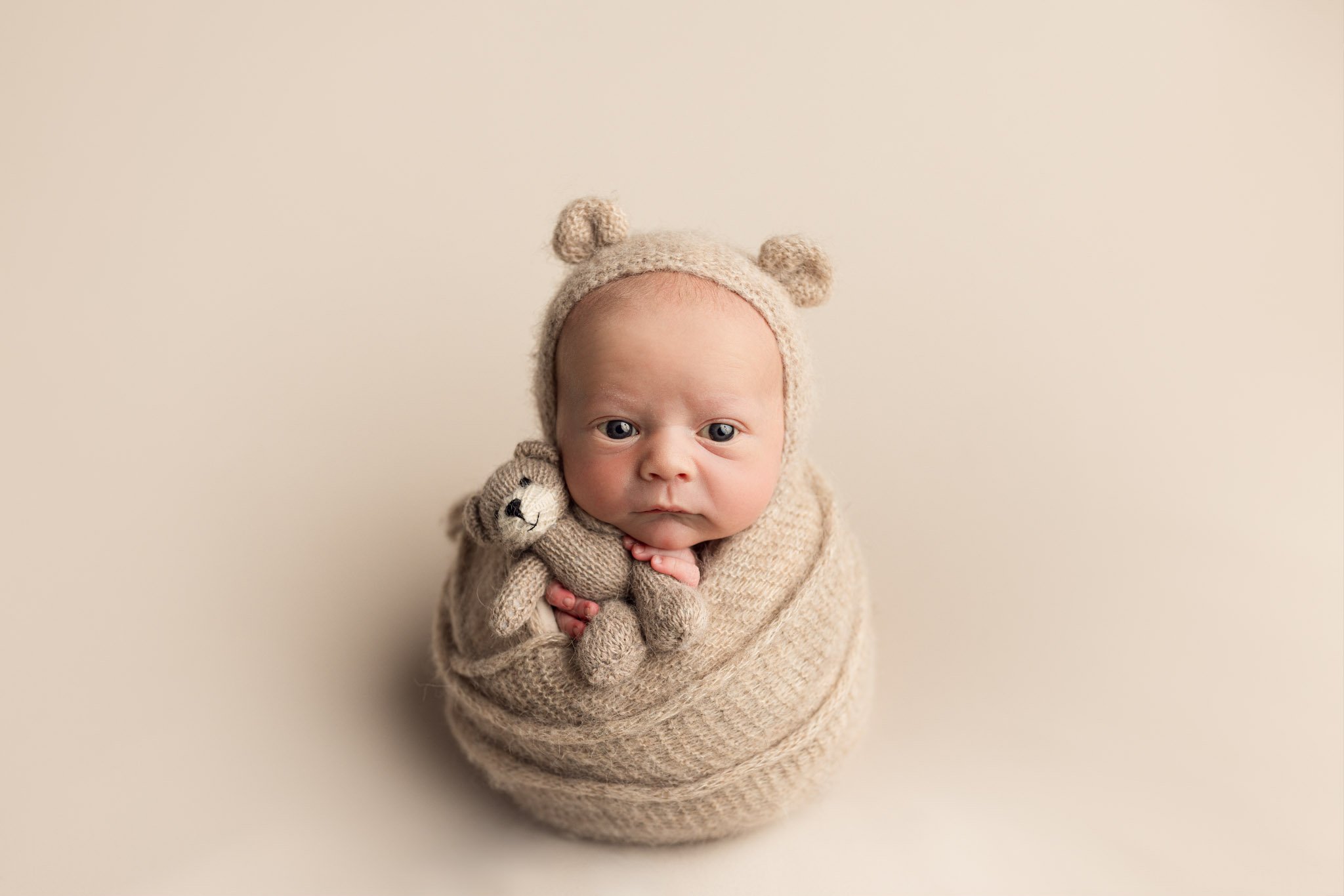 Newborn Bear Wrap Pose – Cozy Studio Portrait in Neutral Tones