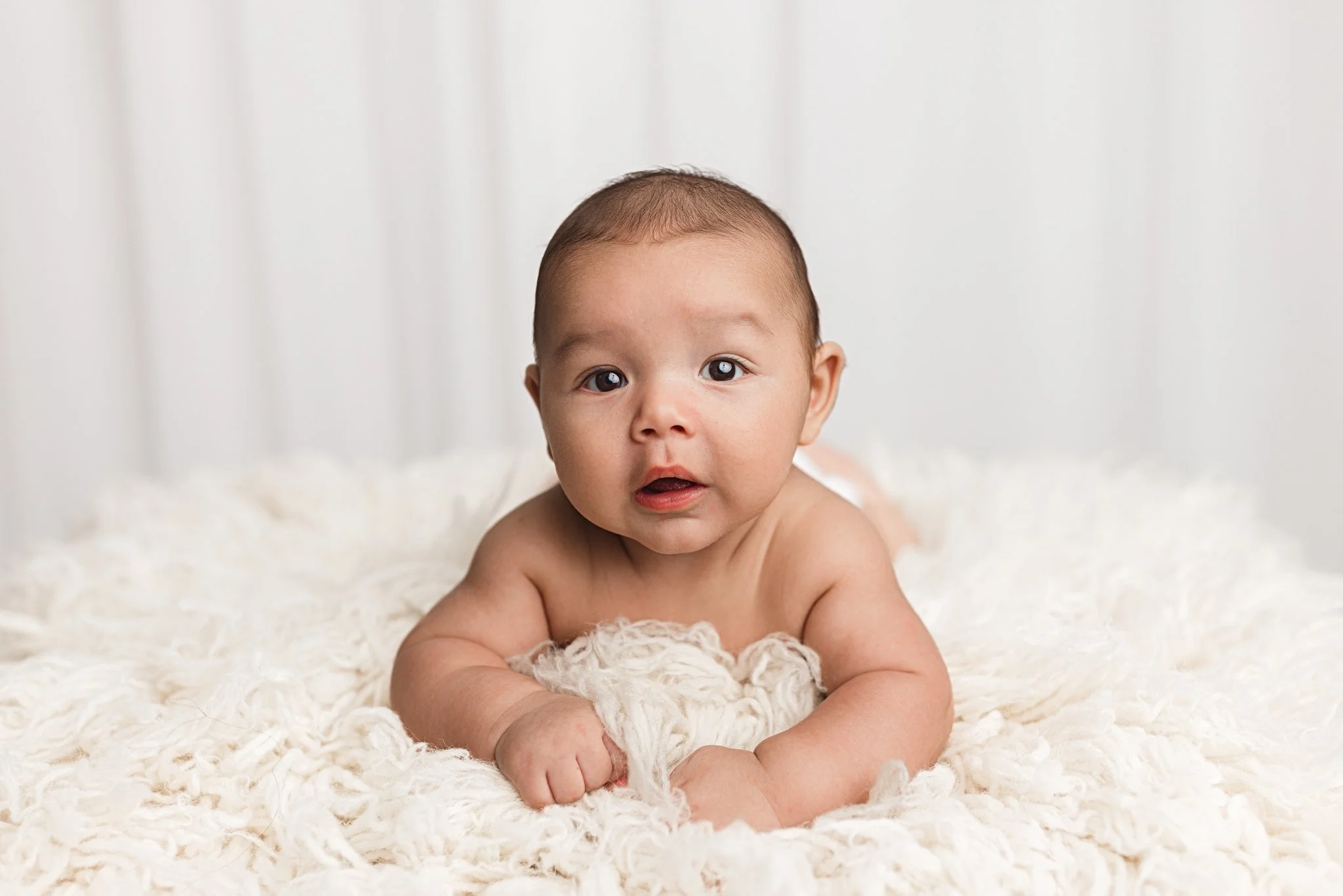 4 months old baby boy doing a tummy time for his portrait session
