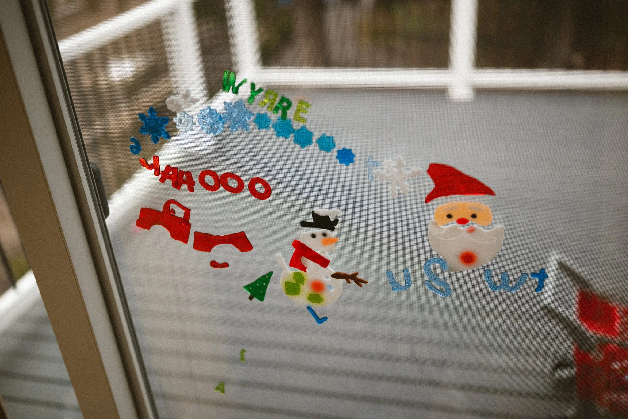Colorful holiday window stickers with a snowman and Santa decorate a family’s home during an in-home newborn photography session in Seattle.