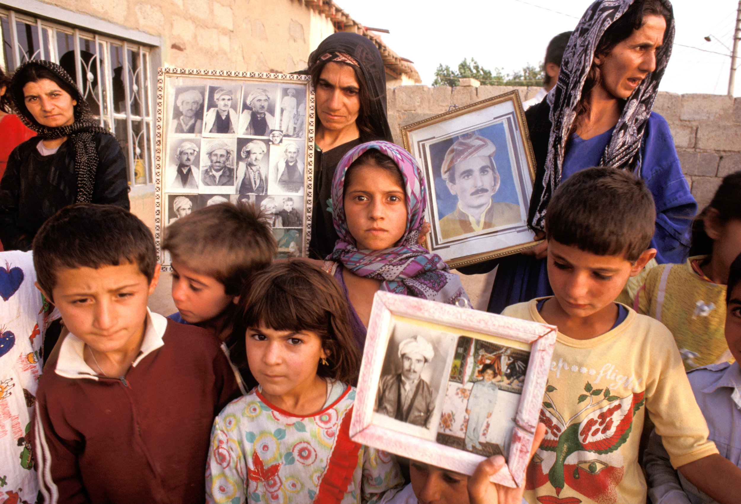 Women and children hold photos of their husbands and fathers abducted and killed by Saddam Hussein. Qushteppe. Northern Iraq. Kurdistan
