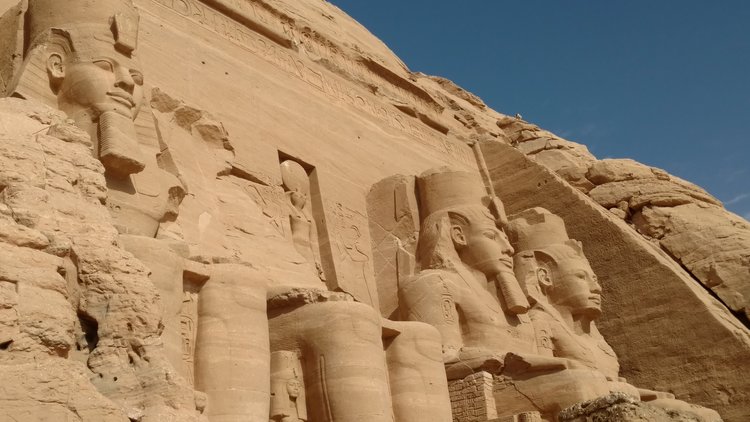 egypt travel tips - Do's and Don'ts: 4 large statues of pharaohs, one of which has toppled over and broken on the ground.