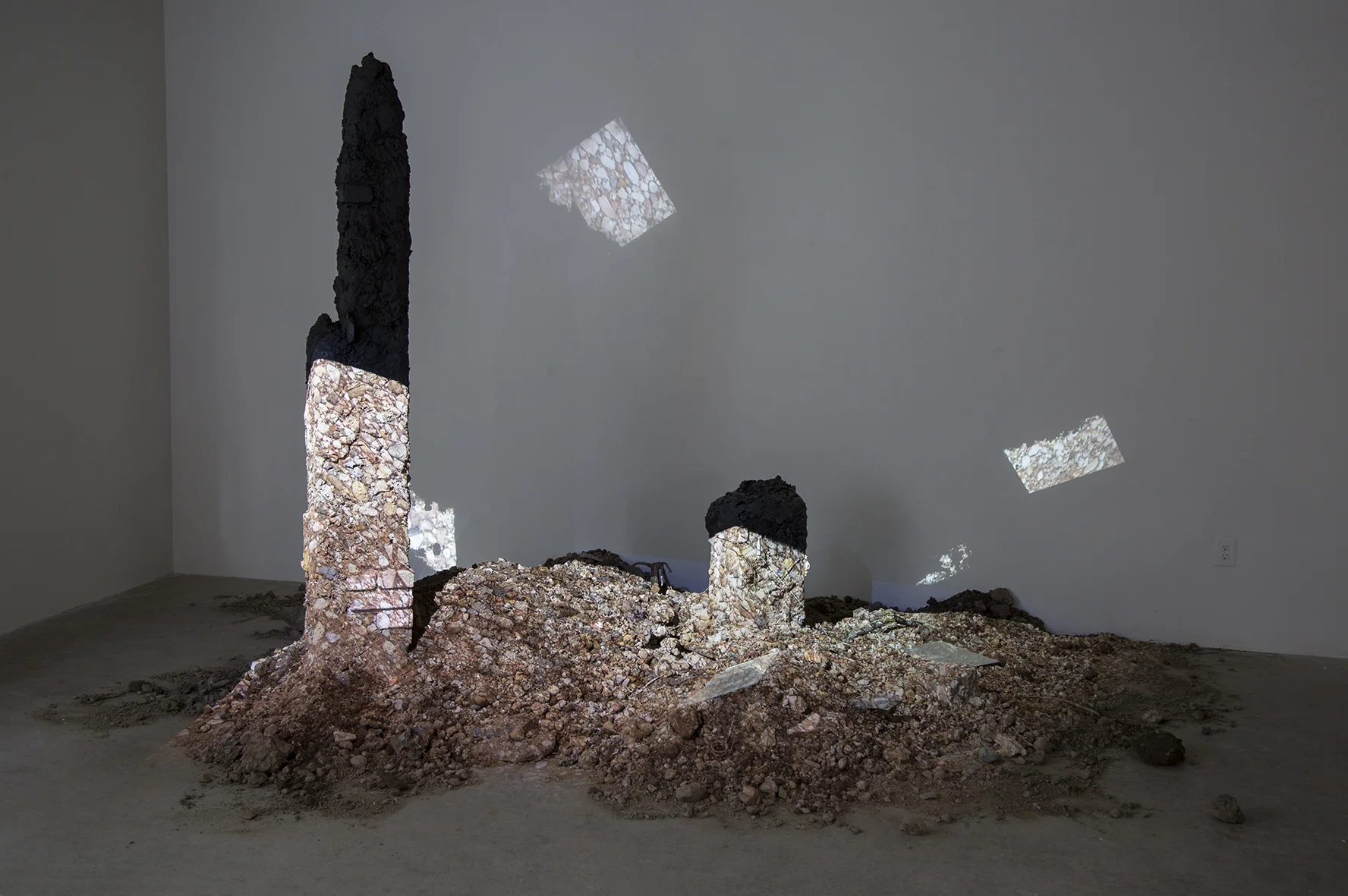earth, stone, detritus, trash, brick, ammonite fossils, mirror, rubber, sticks, lichen, projected image of New Mexico ground; dimensions variable