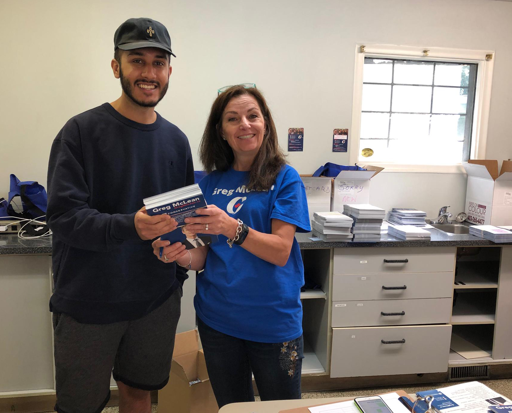 Ruth Pogue hands out a package of literature to be delivered by this volunteer. All of the literature we were hoping would be delivered this weekend, did go out the door. The rest will be delivered by Canada Post all this week.