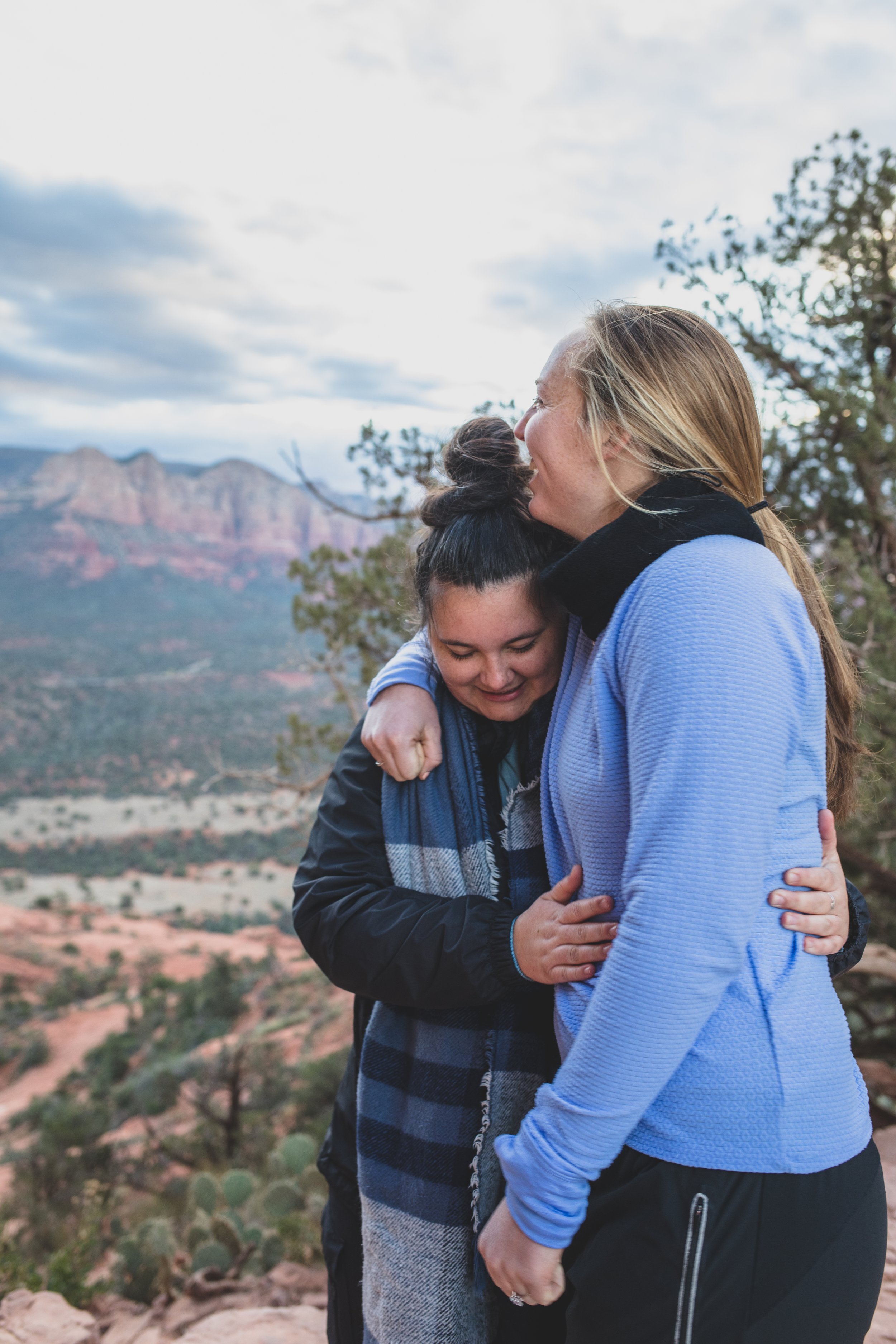  Same Sex Couple Hugs at their Sunrise Proposal at Cathedral Rock in Sedona by Arizona Photographer Jennifer Lind Schutsky  