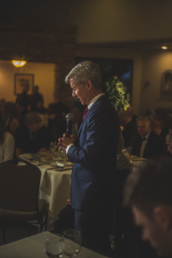  Guests say a prayer before dinner at Christmas theme wedding reception at Grayhawk Golf Club by Scottsdale Wedding Photographer Jennifer Lind Schutsky. 