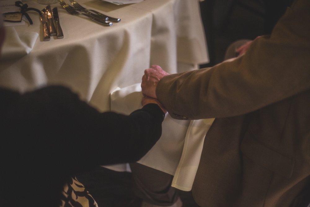  Guests say a prayer before dinner at Christmas theme wedding reception at Grayhawk Golf Club by Scottsdale Wedding Photographer Jennifer Lind Schutsky. 