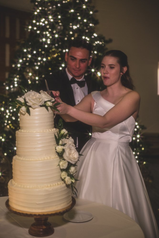  Bride and Groom cut cake at Christmas theme wedding reception at Grayhawk Golf Club by Scottsdale Wedding Photographer Jennifer Lind Schutsky. 