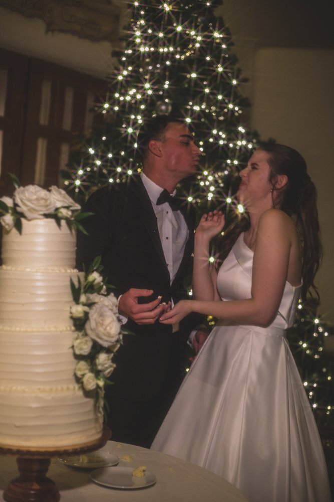  Bride and Groom cut cake at Christmas theme wedding reception at Grayhawk Golf Club by Scottsdale Wedding Photographer Jennifer Lind Schutsky. 