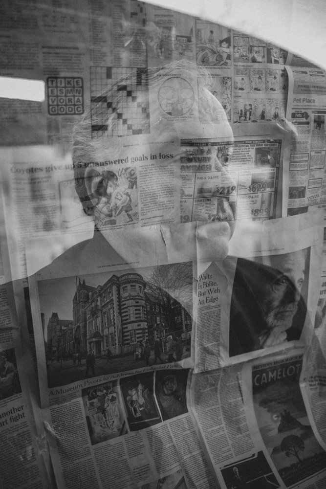 Family poses in front of handcrafter newspaper backdrop for creative session with creative phoenix photographer; Jennifer Lind Schutsky. 