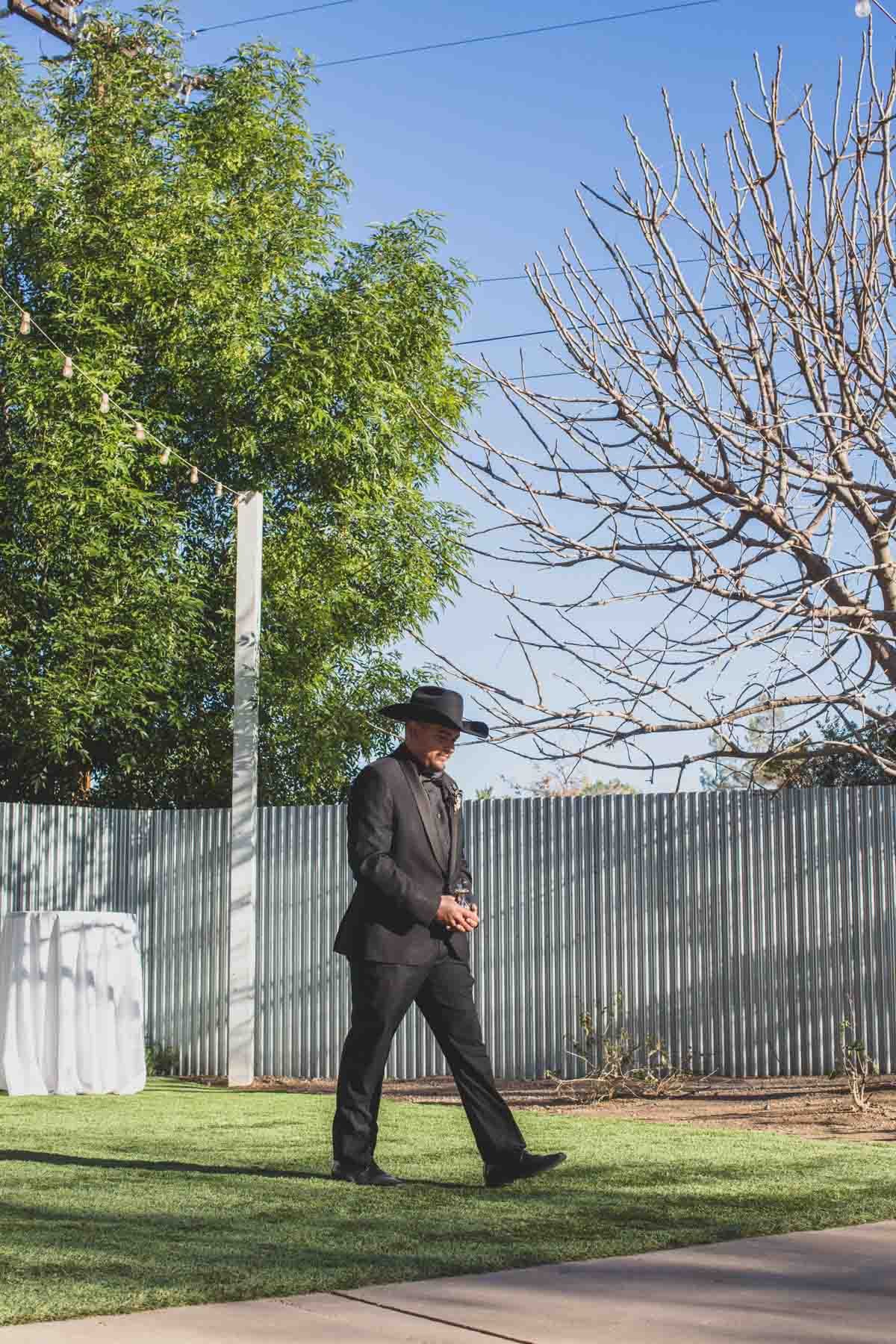  Groom walking down the aisle at Mexican Cowboy / Vaquero Farm Wedding at the Big Red Barn wedding at Schnepf Farms in Queen Creek, Arizona by Arizona based Photographer, Jennifer Lind Schutsky. 