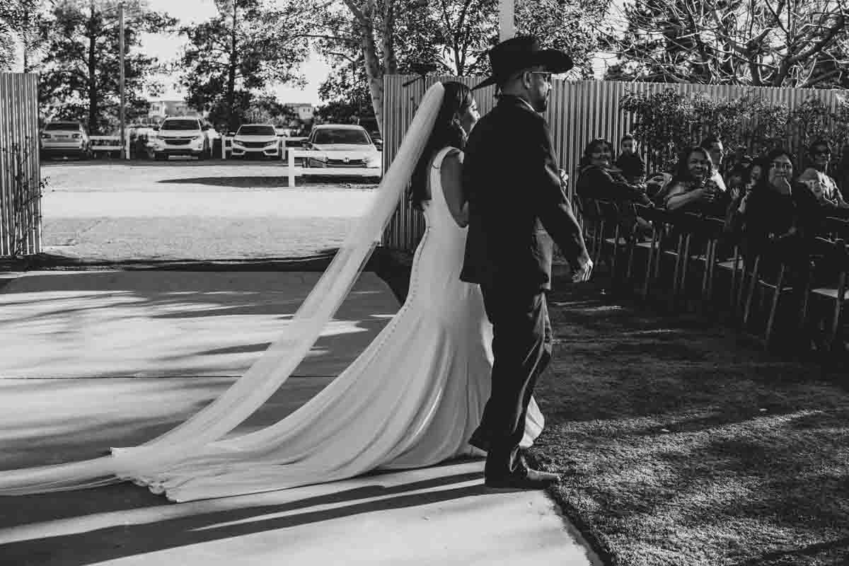  Bride and her father walking down the aisle at Mexican Cowboy / Vaquero Farm Wedding at the Big Red Barn wedding at Schnepf Farms in Queen Creek, Arizona by Arizona based Photographer, Jennifer Lind Schutsky. 