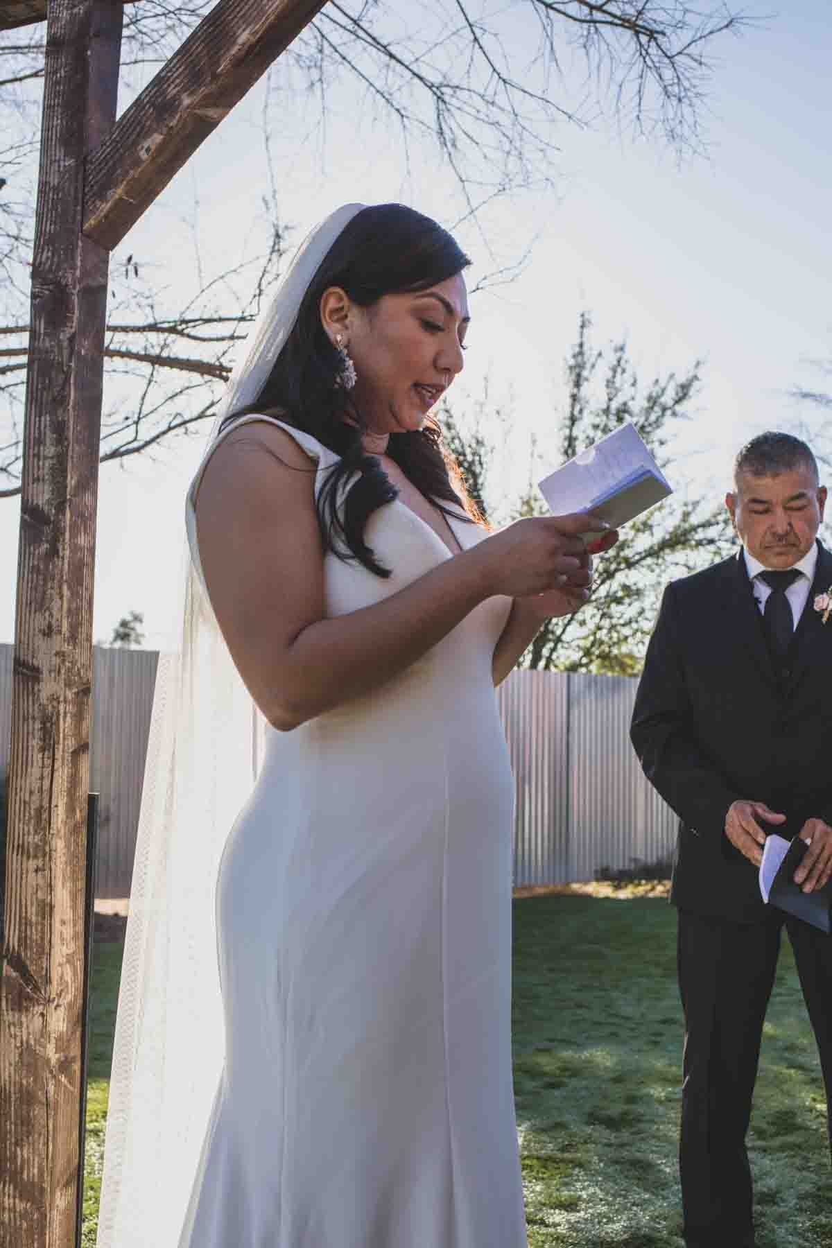  Bride reads her vows at Mexican Cowboy / Vaquero Farm Wedding at the Big Red Barn wedding at Schnepf Farms in Queen Creek, Arizona by Arizona based Photographer, Jennifer Lind Schutsky. 