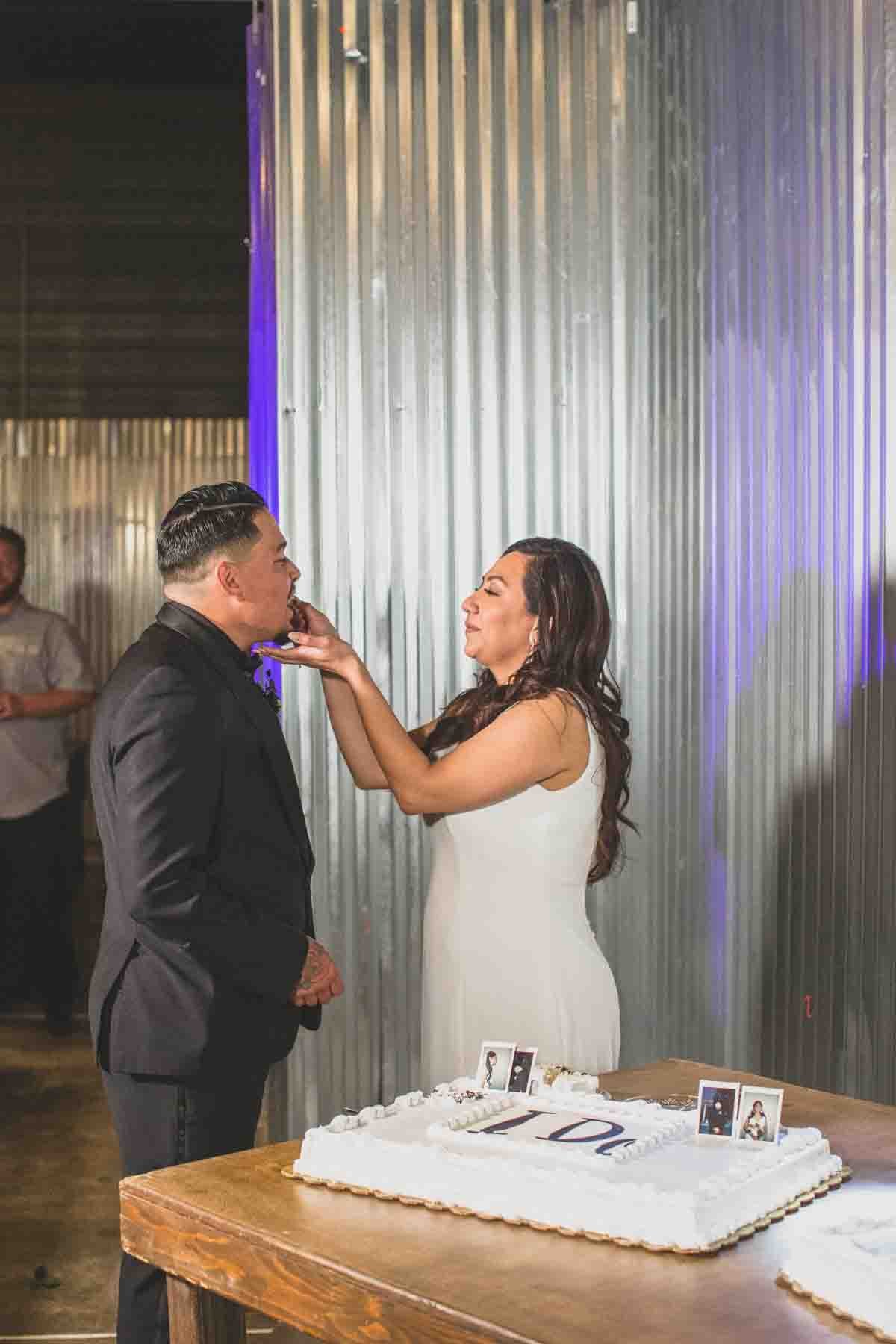  Newlyweds cut simple wedding cake at their Wedding Reception Celebration at Mexican Cowboy / Vaquero Farm Wedding at the Big Red Barn wedding at Schnepf Farms in Queen Creek, Arizona by Arizona based Photographer, Jennifer Lind Schutsky. 