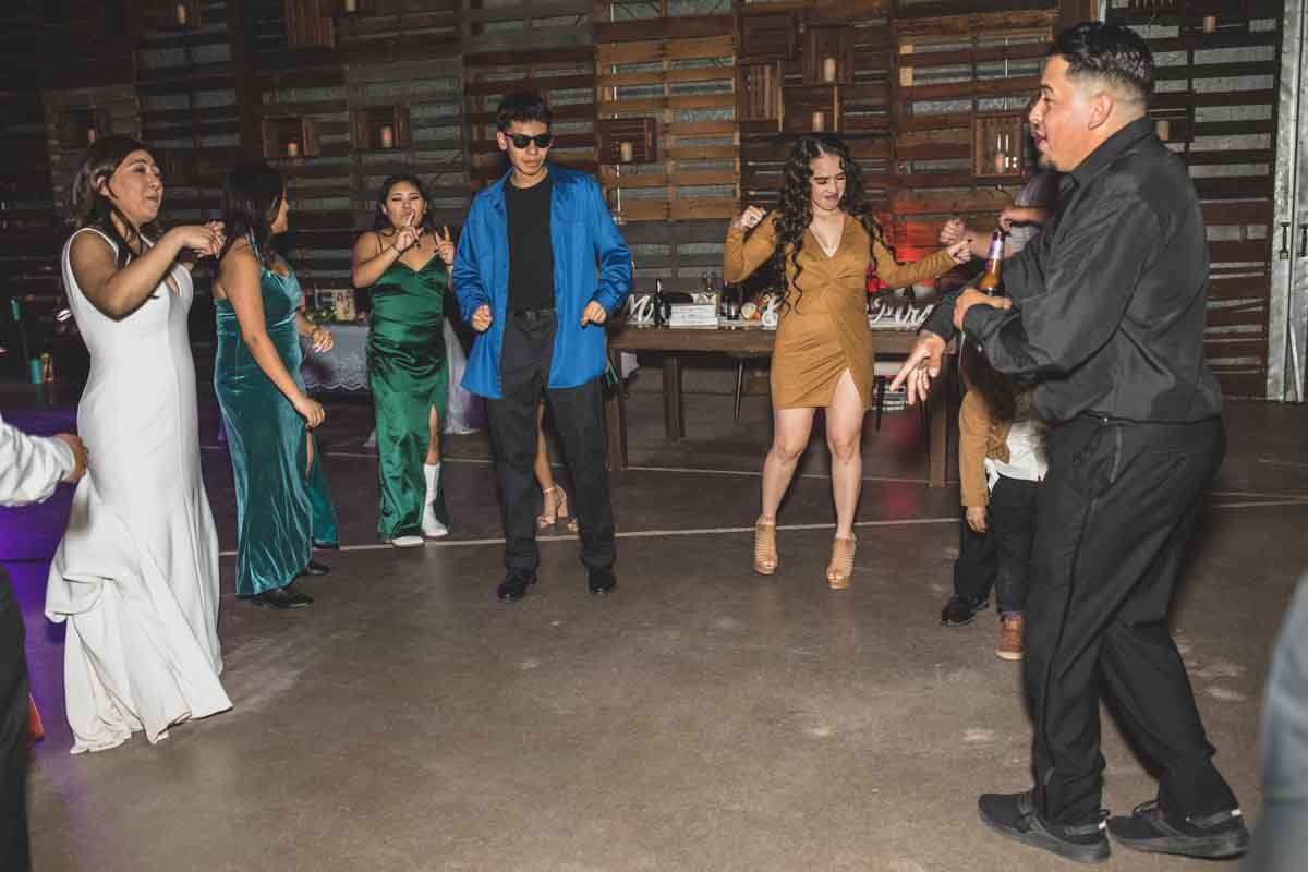  Bride and her guests dance at their Wedding Reception Celebration at Mexican Cowboy / Vaquero Farm Wedding at the Big Red Barn wedding at Schnepf Farms in Queen Creek, Arizona by Destination Wedding Photographer, Jennifer Lind Schutsky. 