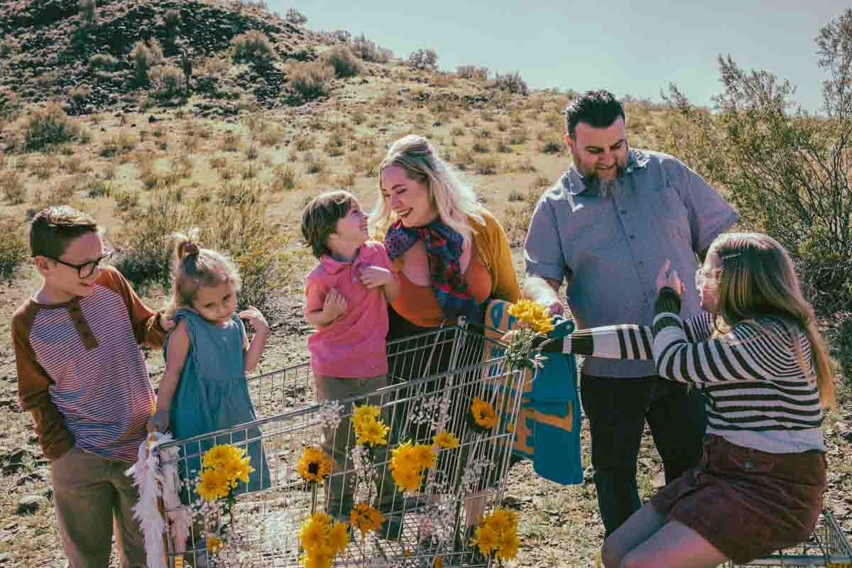  Family posing ideas with shopping cart and yellow flowers props during Creative Photography Family Session with best Phoenix family photographer, Jennifer Lind Schutsky. 