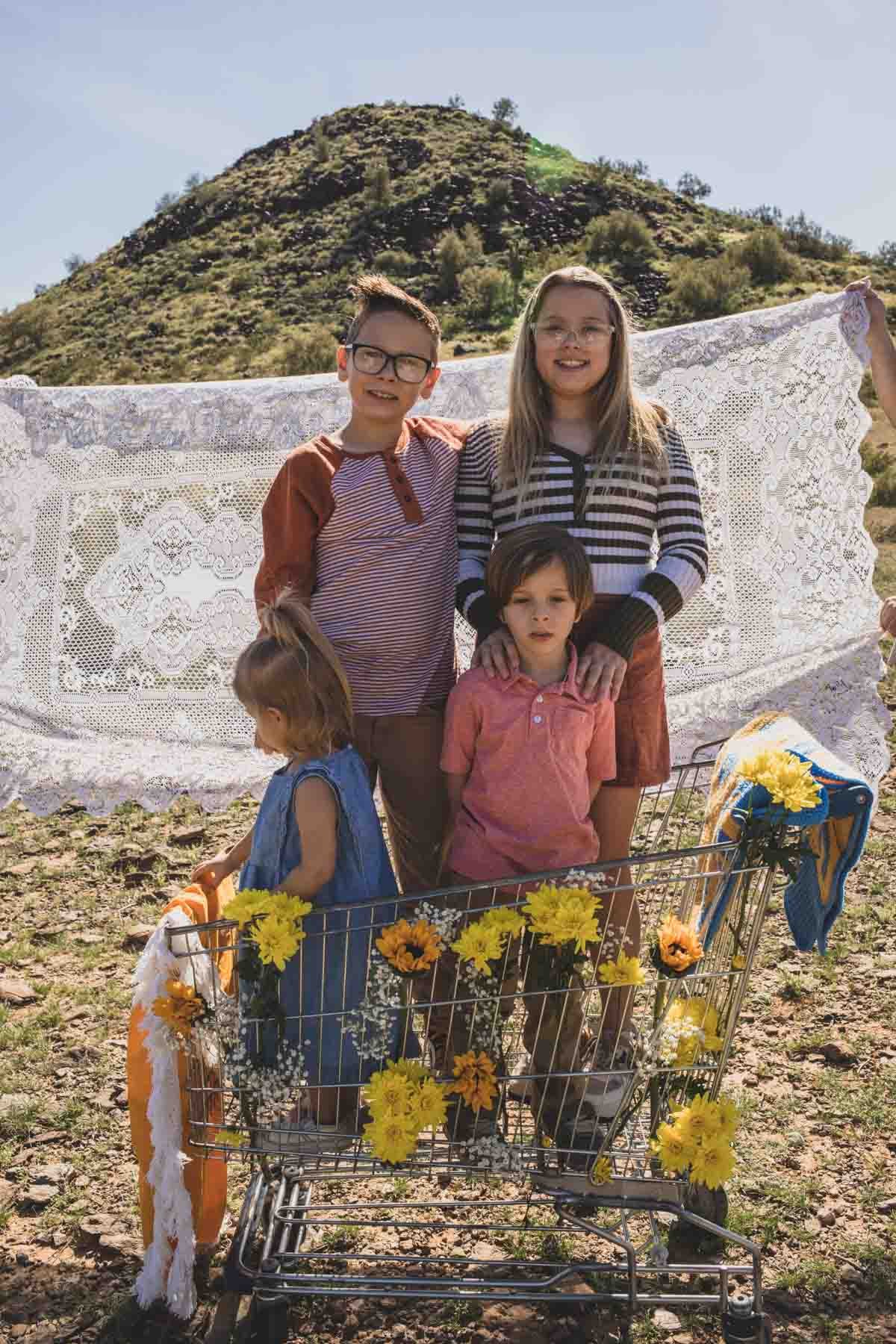  Family posing ideas with shopping cart and yellow flowers props during Creative Photography Family Session with best Phoenix family photographer, Jennifer Lind Schutsky. 