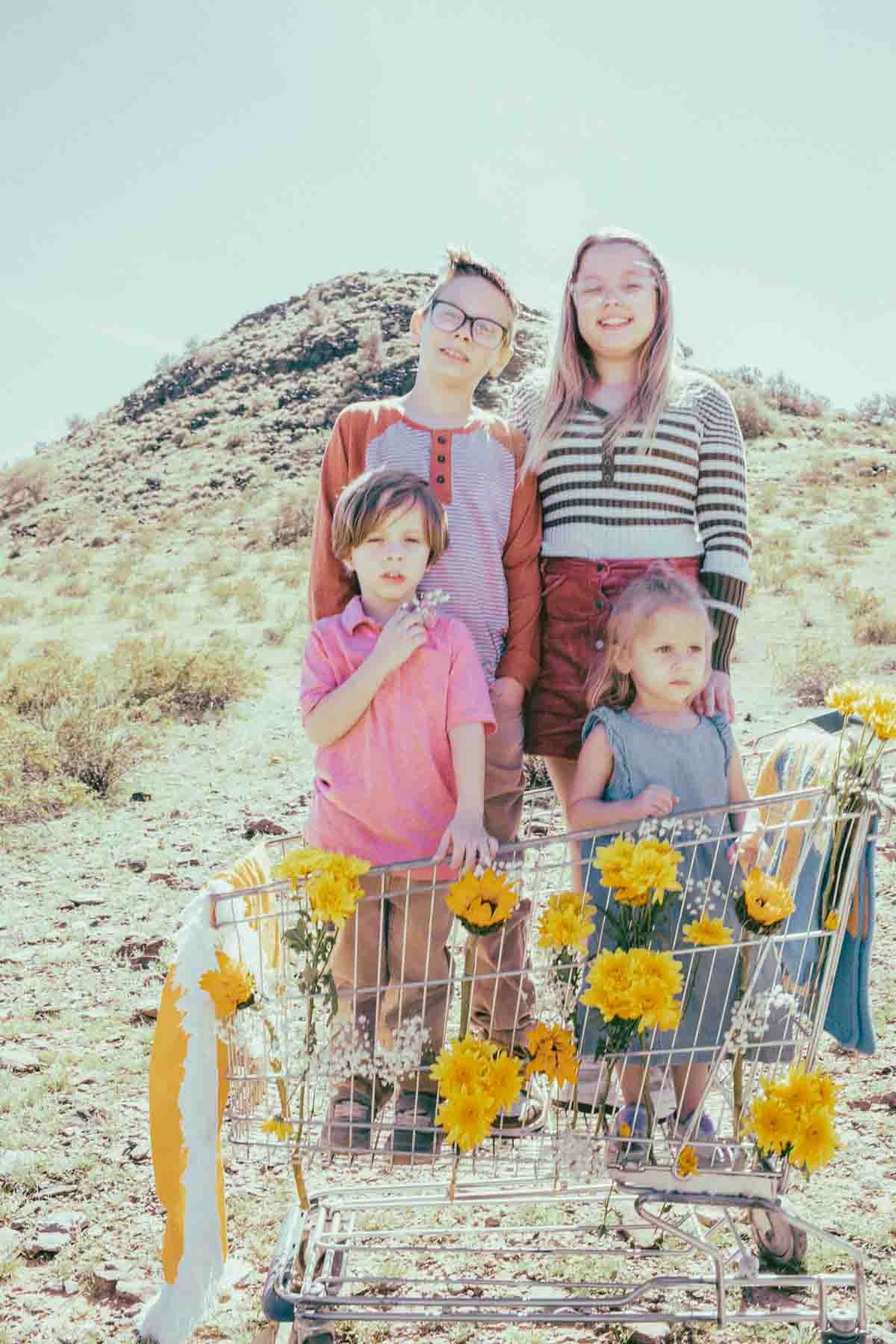  Family posing ideas with shopping cart and yellow flowers props during Creative Photography Family Session with best Phoenix family photographer, Jennifer Lind Schutsky. 