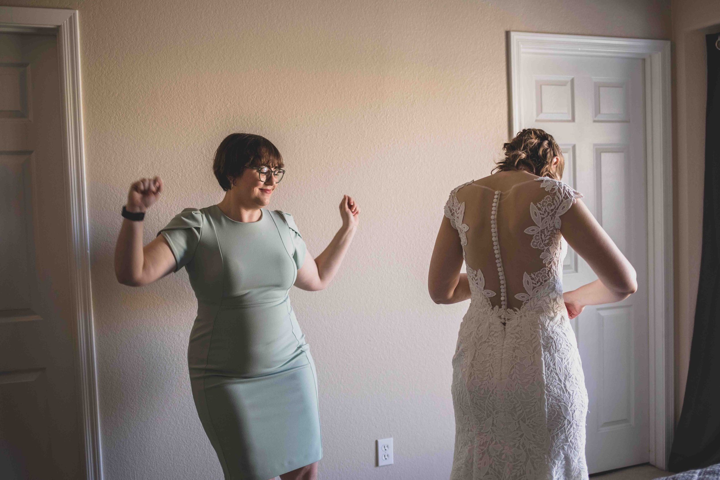  Maid of Honor helping Bride get ready  for her wedding day by Gilbert Wedding Photographer Jennifer Lind Schutsky. 